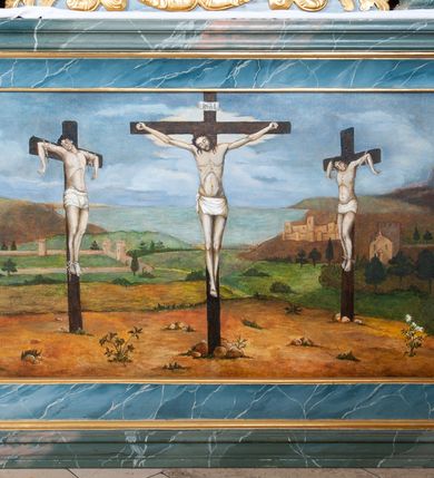 Zdjęcie nr 5: Ołtarz drewniany, prostopadłościenny z drewnianą mensą, w polu antepedium malowana na drewnie scena Ukrzyżowania. Na ołtarzu stoi tabliczka z kanonem w otoczeniu akantowych wolut tworzących podstawę dla pięciu lichtarzy utworzonych z ornamentu roślinnego (brak środkowego). 
Nastawa architektoniczna, jednoosiowa, jednokondygnacyjna ze zwieńczeniem, ustawiona na dwustrefowym cokole, ujęta parą półfilarów i stojącą przed nimi parą kolumn dźwigających pełne belkowanie, przerwane nad polem środkowym. Na cokołach kolumn kanony w ornamentalnych ramach. Kolumny flankują od zewnątrz figury św. Floriana i św. Longina, od wewnątrz św. Donata i św. Marcina. W polu głównym obraz Ukrzyżowania w formie stojącego prostokąta zamkniętego łukiem półkolistym nadwieszonym z uskokiem w profilowanej, dekorowanej ornamentem roślinnym ramie. Ponad nim kartusz ujęty ornamentem rocaille'owym i kratką regencyjną oraz uskrzydlona główka anielska flankowana rocaille'ami. Zwieńczenie w formie leżącego prostokąta ujętego spływami wolutowymi dekorowanymi rocaille'ami, zamkniętego fragmentem falującego gzymsu z monogramem IHS w otoku z obłoków w glorii promienistej. W polu rzeźbiarskie przedstawienie św. Antoniego Padewskiego flankowanego obłokami i wiązkami promieni oraz parą puttów. Na belkowaniu figury św. Walentego i św. Jana Chryzostoma. Ołtarz ujęty uszami utworzonymi z ornamentu rocaille'owego i kratki regencyjnej. Struktura polichromowana w sposób naśladujący marmoryzację w kolorze niebiesko-białym, profile i ornamentyka pozłacane.