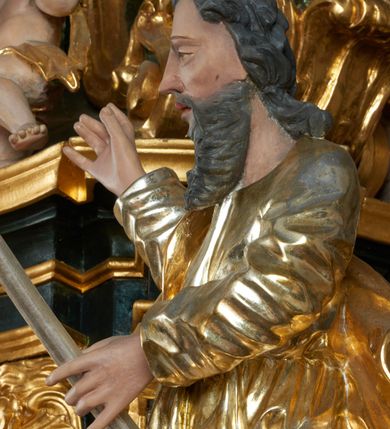Zdjęcie nr 40: Ołtarz dwustronny, sarkofagowy, dekorowany rocaille'm, mensa drewniana na planie kwadratu, od frontu z kamiennym portatylem.
Nastawa ołtarzowa dwustronna, na rzucie leżącej litery X, w formie  rozbudowanego tabernakulum z tronem wystawienia. Obie strony są analogiczne pod względem architektonicznym. Tabernakulum na cokole, o wypukłej ściance frontowej, flankowanej parą pilastrów o trzonach dekorowanym płycinami z rocaille'm, dźwigających gzyms wieńczący. W polu drzwiczki ujęte rokokowym kartuszem. Na tabernakulum tron wystawienia o wklęsło-wypukłym licu, ujęty parą impostów podtrzymywanych przez rocaille'owe konsole oraz pilastrami w narożach, których trzony przyjmują formę spływów wolutowych, sięgające podstawy tabernakulum, na których stoją figury. W polu środkowym tronu wystawienia znajduje się obrotowa nisza o nieregularnym kształcie ujęta obramieniem z rocaille'u, przesłonięta wypukłą ścianką z płaskorzeźbionym krucyfiksem  i winnym gronem, zwieńczona rzeźbioną półpostacią. Całość wieńczy cokół z dwoma ramionami, na których stoją rocaille'owe wazony. Na cokole osadzona jest dużych rozmiarów, dwustronna, dwunastoramienna gwiazda relikwiarzowa, miażdżąca węża. Gwiazda z obu stron ujęta jest kilkoma pierścieniami z winnego grona oraz ornamentu roślinnego, w ramionach oraz w polu głównym umieszczone są za szkłem relikwie wśród kwiatowych dekoracji. 
Na awersie ołtarza, na mensie znajdują się dwie figurki puttów siedzących na obłokach i trzymających tabliczki z kanonami. Całość flankują ustawione na spływach wolutowych figury św. Jana Ewangelisty i św. Bartłomieja, tron wieńczy półpostać Boga Ojca, ujęta przez dwa putta z otwartymi księgami. Obrotową niszę flankują dwa aniołki trzymające lichtarze. Na rewersie ołtarza na spływach wolutowych stoją figury św. Andrzeja i św. Piotra, tron wieńczy półpostać Mojżesza flankowana przez dwa putta z otwartymi księgami.
Struktura polichromowana w kolorze ciemnozielonym, ornamentyka i profile złocone, detal srebrzony.

