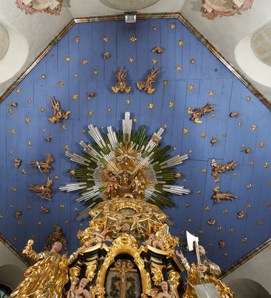 Zdjęcie nr 17: Ołtarz dwustronny, sarkofagowy, dekorowany rocaille'm, mensa drewniana na planie kwadratu, od frontu z kamiennym portatylem.
Nastawa ołtarzowa dwustronna, na rzucie leżącej litery X, w formie  rozbudowanego tabernakulum z tronem wystawienia. Obie strony są analogiczne pod względem architektonicznym. Tabernakulum na cokole, o wypukłej ściance frontowej, flankowanej parą pilastrów o trzonach dekorowanym płycinami z rocaille'm, dźwigających gzyms wieńczący. W polu drzwiczki ujęte rokokowym kartuszem. Na tabernakulum tron wystawienia o wklęsło-wypukłym licu, ujęty parą impostów podtrzymywanych przez rocaille'owe konsole oraz pilastrami w narożach, których trzony przyjmują formę spływów wolutowych, sięgające podstawy tabernakulum, na których stoją figury. W polu środkowym tronu wystawienia znajduje się obrotowa nisza o nieregularnym kształcie ujęta obramieniem z rocaille'u, przesłonięta wypukłą ścianką z płaskorzeźbionym krucyfiksem  i winnym gronem, zwieńczona rzeźbioną półpostacią. Całość wieńczy cokół z dwoma ramionami, na których stoją rocaille'owe wazony. Na cokole osadzona jest dużych rozmiarów, dwustronna, dwunastoramienna gwiazda relikwiarzowa, miażdżąca węża. Gwiazda z obu stron ujęta jest kilkoma pierścieniami z winnego grona oraz ornamentu roślinnego, w ramionach oraz w polu głównym umieszczone są za szkłem relikwie wśród kwiatowych dekoracji. 
Na awersie ołtarza, na mensie znajdują się dwie figurki puttów siedzących na obłokach i trzymających tabliczki z kanonami. Całość flankują ustawione na spływach wolutowych figury św. Jana Ewangelisty i św. Bartłomieja, tron wieńczy półpostać Boga Ojca, ujęta przez dwa putta z otwartymi księgami. Obrotową niszę flankują dwa aniołki trzymające lichtarze. Na rewersie ołtarza na spływach wolutowych stoją figury św. Andrzeja i św. Piotra, tron wieńczy półpostać Mojżesza flankowana przez dwa putta z otwartymi księgami.
Struktura polichromowana w kolorze ciemnozielonym, ornamentyka i profile złocone, detal srebrzony.
