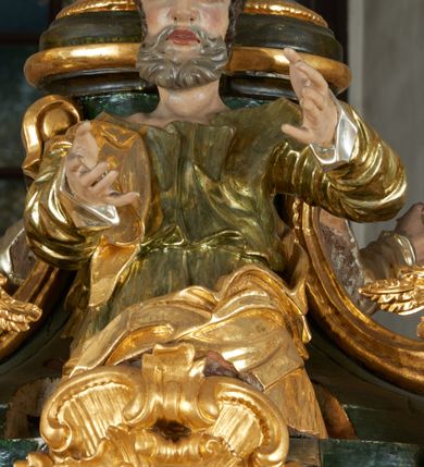 Zdjęcie nr 29: Ołtarz dwustronny, sarkofagowy, dekorowany rocaille'm, mensa drewniana na planie kwadratu, od frontu z kamiennym portatylem.
Nastawa ołtarzowa dwustronna, na rzucie leżącej litery X, w formie  rozbudowanego tabernakulum z tronem wystawienia. Obie strony są analogiczne pod względem architektonicznym. Tabernakulum na cokole, o wypukłej ściance frontowej, flankowanej parą pilastrów o trzonach dekorowanym płycinami z rocaille'm, dźwigających gzyms wieńczący. W polu drzwiczki ujęte rokokowym kartuszem. Na tabernakulum tron wystawienia o wklęsło-wypukłym licu, ujęty parą impostów podtrzymywanych przez rocaille'owe konsole oraz pilastrami w narożach, których trzony przyjmują formę spływów wolutowych, sięgające podstawy tabernakulum, na których stoją figury. W polu środkowym tronu wystawienia znajduje się obrotowa nisza o nieregularnym kształcie ujęta obramieniem z rocaille'u, przesłonięta wypukłą ścianką z płaskorzeźbionym krucyfiksem  i winnym gronem, zwieńczona rzeźbioną półpostacią. Całość wieńczy cokół z dwoma ramionami, na których stoją rocaille'owe wazony. Na cokole osadzona jest dużych rozmiarów, dwustronna, dwunastoramienna gwiazda relikwiarzowa, miażdżąca węża. Gwiazda z obu stron ujęta jest kilkoma pierścieniami z winnego grona oraz ornamentu roślinnego, w ramionach oraz w polu głównym umieszczone są za szkłem relikwie wśród kwiatowych dekoracji. 
Na awersie ołtarza, na mensie znajdują się dwie figurki puttów siedzących na obłokach i trzymających tabliczki z kanonami. Całość flankują ustawione na spływach wolutowych figury św. Jana Ewangelisty i św. Bartłomieja, tron wieńczy półpostać Boga Ojca, ujęta przez dwa putta z otwartymi księgami. Obrotową niszę flankują dwa aniołki trzymające lichtarze. Na rewersie ołtarza na spływach wolutowych stoją figury św. Andrzeja i św. Piotra, tron wieńczy półpostać Mojżesza flankowana przez dwa putta z otwartymi księgami.
Struktura polichromowana w kolorze ciemnozielonym, ornamentyka i profile złocone, detal srebrzony.
