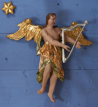 Zdjęcie nr 22: Ołtarz dwustronny, sarkofagowy, dekorowany rocaille'm, mensa drewniana na planie kwadratu, od frontu z kamiennym portatylem.
Nastawa ołtarzowa dwustronna, na rzucie leżącej litery X, w formie  rozbudowanego tabernakulum z tronem wystawienia. Obie strony są analogiczne pod względem architektonicznym. Tabernakulum na cokole, o wypukłej ściance frontowej, flankowanej parą pilastrów o trzonach dekorowanym płycinami z rocaille'm, dźwigających gzyms wieńczący. W polu drzwiczki ujęte rokokowym kartuszem. Na tabernakulum tron wystawienia o wklęsło-wypukłym licu, ujęty parą impostów podtrzymywanych przez rocaille'owe konsole oraz pilastrami w narożach, których trzony przyjmują formę spływów wolutowych, sięgające podstawy tabernakulum, na których stoją figury. W polu środkowym tronu wystawienia znajduje się obrotowa nisza o nieregularnym kształcie ujęta obramieniem z rocaille'u, przesłonięta wypukłą ścianką z płaskorzeźbionym krucyfiksem  i winnym gronem, zwieńczona rzeźbioną półpostacią. Całość wieńczy cokół z dwoma ramionami, na których stoją rocaille'owe wazony. Na cokole osadzona jest dużych rozmiarów, dwustronna, dwunastoramienna gwiazda relikwiarzowa, miażdżąca węża. Gwiazda z obu stron ujęta jest kilkoma pierścieniami z winnego grona oraz ornamentu roślinnego, w ramionach oraz w polu głównym umieszczone są za szkłem relikwie wśród kwiatowych dekoracji. 
Na awersie ołtarza, na mensie znajdują się dwie figurki puttów siedzących na obłokach i trzymających tabliczki z kanonami. Całość flankują ustawione na spływach wolutowych figury św. Jana Ewangelisty i św. Bartłomieja, tron wieńczy półpostać Boga Ojca, ujęta przez dwa putta z otwartymi księgami. Obrotową niszę flankują dwa aniołki trzymające lichtarze. Na rewersie ołtarza na spływach wolutowych stoją figury św. Andrzeja i św. Piotra, tron wieńczy półpostać Mojżesza flankowana przez dwa putta z otwartymi księgami.
Struktura polichromowana w kolorze ciemnozielonym, ornamentyka i profile złocone, detal srebrzony.
