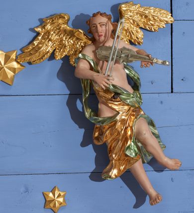 Zdjęcie nr 26: Ołtarz dwustronny, sarkofagowy, dekorowany rocaille'm, mensa drewniana na planie kwadratu, od frontu z kamiennym portatylem.
Nastawa ołtarzowa dwustronna, na rzucie leżącej litery X, w formie  rozbudowanego tabernakulum z tronem wystawienia. Obie strony są analogiczne pod względem architektonicznym. Tabernakulum na cokole, o wypukłej ściance frontowej, flankowanej parą pilastrów o trzonach dekorowanym płycinami z rocaille'm, dźwigających gzyms wieńczący. W polu drzwiczki ujęte rokokowym kartuszem. Na tabernakulum tron wystawienia o wklęsło-wypukłym licu, ujęty parą impostów podtrzymywanych przez rocaille'owe konsole oraz pilastrami w narożach, których trzony przyjmują formę spływów wolutowych, sięgające podstawy tabernakulum, na których stoją figury. W polu środkowym tronu wystawienia znajduje się obrotowa nisza o nieregularnym kształcie ujęta obramieniem z rocaille'u, przesłonięta wypukłą ścianką z płaskorzeźbionym krucyfiksem  i winnym gronem, zwieńczona rzeźbioną półpostacią. Całość wieńczy cokół z dwoma ramionami, na których stoją rocaille'owe wazony. Na cokole osadzona jest dużych rozmiarów, dwustronna, dwunastoramienna gwiazda relikwiarzowa, miażdżąca węża. Gwiazda z obu stron ujęta jest kilkoma pierścieniami z winnego grona oraz ornamentu roślinnego, w ramionach oraz w polu głównym umieszczone są za szkłem relikwie wśród kwiatowych dekoracji. 
Na awersie ołtarza, na mensie znajdują się dwie figurki puttów siedzących na obłokach i trzymających tabliczki z kanonami. Całość flankują ustawione na spływach wolutowych figury św. Jana Ewangelisty i św. Bartłomieja, tron wieńczy półpostać Boga Ojca, ujęta przez dwa putta z otwartymi księgami. Obrotową niszę flankują dwa aniołki trzymające lichtarze. Na rewersie ołtarza na spływach wolutowych stoją figury św. Andrzeja i św. Piotra, tron wieńczy półpostać Mojżesza flankowana przez dwa putta z otwartymi księgami.
Struktura polichromowana w kolorze ciemnozielonym, ornamentyka i profile złocone, detal srebrzony.
