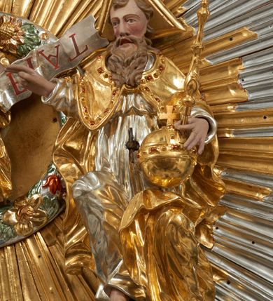 Zdjęcie nr 47: Ołtarz dwustronny, sarkofagowy, dekorowany rocaille'm, mensa drewniana na planie kwadratu, od frontu z kamiennym portatylem.
Nastawa ołtarzowa dwustronna, na rzucie leżącej litery X, w formie  rozbudowanego tabernakulum z tronem wystawienia. Obie strony są analogiczne pod względem architektonicznym. Tabernakulum na cokole, o wypukłej ściance frontowej, flankowanej parą pilastrów o trzonach dekorowanym płycinami z rocaille'm, dźwigających gzyms wieńczący. W polu drzwiczki ujęte rokokowym kartuszem. Na tabernakulum tron wystawienia o wklęsło-wypukłym licu, ujęty parą impostów podtrzymywanych przez rocaille'owe konsole oraz pilastrami w narożach, których trzony przyjmują formę spływów wolutowych, sięgające podstawy tabernakulum, na których stoją figury. W polu środkowym tronu wystawienia znajduje się obrotowa nisza o nieregularnym kształcie ujęta obramieniem z rocaille'u, przesłonięta wypukłą ścianką z płaskorzeźbionym krucyfiksem  i winnym gronem, zwieńczona rzeźbioną półpostacią. Całość wieńczy cokół z dwoma ramionami, na których stoją rocaille'owe wazony. Na cokole osadzona jest dużych rozmiarów, dwustronna, dwunastoramienna gwiazda relikwiarzowa, miażdżąca węża. Gwiazda z obu stron ujęta jest kilkoma pierścieniami z winnego grona oraz ornamentu roślinnego, w ramionach oraz w polu głównym umieszczone są za szkłem relikwie wśród kwiatowych dekoracji. 
Na awersie ołtarza, na mensie znajdują się dwie figurki puttów siedzących na obłokach i trzymających tabliczki z kanonami. Całość flankują ustawione na spływach wolutowych figury św. Jana Ewangelisty i św. Bartłomieja, tron wieńczy półpostać Boga Ojca, ujęta przez dwa putta z otwartymi księgami. Obrotową niszę flankują dwa aniołki trzymające lichtarze. Na rewersie ołtarza na spływach wolutowych stoją figury św. Andrzeja i św. Piotra, tron wieńczy półpostać Mojżesza flankowana przez dwa putta z otwartymi księgami.
Struktura polichromowana w kolorze ciemnozielonym, ornamentyka i profile złocone, detal srebrzony.
