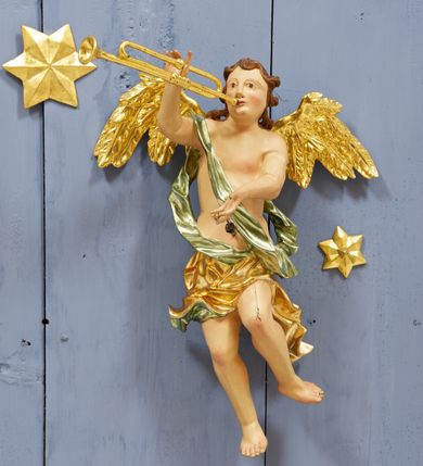 Zdjęcie nr 8: Drewniany, polichromowany na niebiesko strop, na planie ośmioboku, ujęty profilowaną ramą. W jego centrum grupa Koronacji Marii w glorii promienistej. W środku grupy figura Matki Boskiej na tle opaski dekorowanej kwiatami. Maria ukazana frontalnie, w kontrapoście, z rękami złożonymi w geście modlitwy. Twarz ma pociągłą, szczupłą, o młodzieńczych rysach, okoloną długimi włosami, upiętymi z tyłu głowy. Ubrana jest w srebrzoną suknię oraz złocony płaszcz narzucony na ramiona i zawinięty na lewej nodze, na głowie ma koronę zamkniętą. Marię flankują dwie banderole z napisem: „FIAT”. Po jej prawej znacznie większa figura Chrystusa, ukazanego frontalnie, w pozycji siedzącej, z głową skierowaną do wewnątrz; jego lewa ręka spoczywa na piersi, prawa jest ugięta i uniesiona w geście wskazującym. Twarz ma pociągłą, szczupłą, okoloną brodą skręconą w dwa pukle, oraz kręconymi włosami. Chrystus przewiązany jest w partii bioder złoconym płaszczem otaczającym postać i odsłaniającym lewą nogę. Jego ciało w odsłoniętych partiach, ma delikatnie zarysowaną muskulaturę, z zaznaczonymi śladami męki. Po lewej stronie Marii znacznie większa figura Boga Ojca, ukazanego frontalnie, w pozycji siedzącej. Lewą ręką przytrzymuje jabłko królewskie, w dłoni dzierży berło, prawą wyciąga w geście błogosławieństwa. Twarz ma pociągłą, o starczych rysach, okoloną długą, kręconą brodą opadającą na pierś oraz krótkimi włosami. Ubrany jest w obficie drapowaną srebrzoną tunikę, przepasaną w talii oraz złocony płaszcz z dekoracyjną, kameryzowaną lamówką, zapięty na piersi i opadający na boki, z zawiniętym fragmentem tkaniny na lewej nodze. Nad postaciami nadlatująca gołębica Ducha Świętego w glorii promienistej z banderolą z napisem: „FIAT”. Grupa na tle trzystrefowej glorii promienistej dekorowanej gwiazdami i uskrzydlonymi główkami anielskimi. Glorię z grupą Koronacji otacza dwunastu aniołów, ułożonych naprzemiennie w cztery pary muzykujących postaci (ze skrzypcami, wiolonczelą, gitarą, trąbką, harfą) z czterema aniołami podtrzymującymi tace z symbolicznymi przedmiotami (różaniec, wieniec laurowy, chleb (?), dyscyplina). Strop dekorowany jest w całości gwiazdami i uskrzydlonymi główkami anielskimi. Figury w partiach ciała polichromowane są naturalistycznie, ich szaty są złocone, srebrzone i laserowane; atrybuty są srebrzone. 

