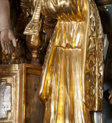 Zdjęcie nr 14: Nastawa ołtarzowa architektoniczna, trójosiowa z bramkami, dwukondygnacyjna, na dwustrefowym cokole. Ołtarz kamienny, prostopadłościenny, w drewnianej obudowie. Antepedium w formie wydłużonego, leżącego prostokąta, w polu obraz Ostatniej Wieczerzy. Mensa drewniana. Osie nastawy wydzielone parą półfilarów ujętych dwiema parami kolumn o kapitelach kompozytowych i skręconych trzonach. Dźwigają one pełne belkowanie silnie wyłamane na osi filarów, z mocno wysuniętym gzymsem, na skraju belkowania przerwany półkolisty przyczółek zwrócony na zewnątrz, na nim cokoły z figurami św. Władysława i św. Stefana. Na tle filarów ustawione figury św. Augustyna i św. Wojciecha, na bramkach rzeźby św. Marcina i św. Jana Jałmużnika. W polu głównym głęboka nisza w formie kwadratu zamkniętego łukiem falistym nadwieszonym, wewnątrz rzeźbiarska scena „Zabójstwa św. Stanisława”. Druga kondygnacja ujęta półfilarami, na tle których znajdują się anioły-kariatydy siedzące na cokołach z wolutami, podtrzymujące imposty. W polu prześwit w formie stojącego prostokąta z wpisanym krzyżem w kształcie litery „X”, przed którym znajduje się figura św. Andrzeja. Całość zwieńczona półpostacią Boga Ojca wśród obłoków i uskrzydlonych główek anielskich w glorii promienistej. Struktura obficie dekorowana ornamentem roślinnym, w partii pierwszej i drugiej kondygnacji uszy utworzone z akantu i wstęgi. Ołtarz flankują dodatkowo dwie pary wolnostojących półfilarów z półkolumnami o skręconych trzonach przed nimi, stojących na dwustrefowych cokołach, dźwigających imposty z figurami. Na zewnętrznej, niższej parze znajdują się figury św. Jana Ewangelisty i św. Jana Chrzciciela, na wewnętrznej, wyższej parze – św. Piotra i św. Pawła. Struktura polichromowana w sposób naśladujący marmoryzację w kolorze niebiesko-szarym, z zielonymi profilami oraz złoconymi kolumnami, profilami i ornamentyką.


