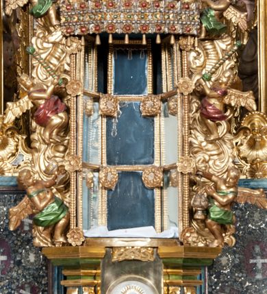 Zdjęcie nr 20: Nastawa ołtarzowa architektoniczna, trójosiowa z bramkami, dwukondygnacyjna, na dwustrefowym cokole. Ołtarz kamienny, prostopadłościenny, w drewnianej obudowie. Antepedium w formie wydłużonego, leżącego prostokąta, w polu obraz Ostatniej Wieczerzy. Mensa drewniana. Osie nastawy wydzielone parą półfilarów ujętych dwiema parami kolumn o kapitelach kompozytowych i skręconych trzonach. Dźwigają one pełne belkowanie silnie wyłamane na osi filarów, z mocno wysuniętym gzymsem, na skraju belkowania przerwany półkolisty przyczółek zwrócony na zewnątrz, na nim cokoły z figurami św. Władysława i św. Stefana. Na tle filarów ustawione figury św. Augustyna i św. Wojciecha, na bramkach rzeźby św. Marcina i św. Jana Jałmużnika. W polu głównym głęboka nisza w formie kwadratu zamkniętego łukiem falistym nadwieszonym, wewnątrz rzeźbiarska scena „Zabójstwa św. Stanisława”. Druga kondygnacja ujęta półfilarami, na tle których znajdują się anioły-kariatydy siedzące na cokołach z wolutami, podtrzymujące imposty. W polu prześwit w formie stojącego prostokąta z wpisanym krzyżem w kształcie litery „X”, przed którym znajduje się figura św. Andrzeja. Całość zwieńczona półpostacią Boga Ojca wśród obłoków i uskrzydlonych główek anielskich w glorii promienistej. Struktura obficie dekorowana ornamentem roślinnym, w partii pierwszej i drugiej kondygnacji uszy utworzone z akantu i wstęgi. Ołtarz flankują dodatkowo dwie pary wolnostojących półfilarów z półkolumnami o skręconych trzonach przed nimi, stojących na dwustrefowych cokołach, dźwigających imposty z figurami. Na zewnętrznej, niższej parze znajdują się figury św. Jana Ewangelisty i św. Jana Chrzciciela, na wewnętrznej, wyższej parze – św. Piotra i św. Pawła. Struktura polichromowana w sposób naśladujący marmoryzację w kolorze niebiesko-szarym, z zielonymi profilami oraz złoconymi kolumnami, profilami i ornamentyką.


