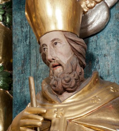 Zdjęcie nr 33: Nastawa ołtarzowa architektoniczna, trójosiowa z bramkami, dwukondygnacyjna, na dwustrefowym cokole. Ołtarz kamienny, prostopadłościenny, w drewnianej obudowie. Antepedium w formie wydłużonego, leżącego prostokąta, w polu obraz Ostatniej Wieczerzy. Mensa drewniana. Osie nastawy wydzielone parą półfilarów ujętych dwiema parami kolumn o kapitelach kompozytowych i skręconych trzonach. Dźwigają one pełne belkowanie silnie wyłamane na osi filarów, z mocno wysuniętym gzymsem, na skraju belkowania przerwany półkolisty przyczółek zwrócony na zewnątrz, na nim cokoły z figurami św. Władysława i św. Stefana. Na tle filarów ustawione figury św. Augustyna i św. Wojciecha, na bramkach rzeźby św. Marcina i św. Jana Jałmużnika. W polu głównym głęboka nisza w formie kwadratu zamkniętego łukiem falistym nadwieszonym, wewnątrz rzeźbiarska scena „Zabójstwa św. Stanisława”. Druga kondygnacja ujęta półfilarami, na tle których znajdują się anioły-kariatydy siedzące na cokołach z wolutami, podtrzymujące imposty. W polu prześwit w formie stojącego prostokąta z wpisanym krzyżem w kształcie litery „X”, przed którym znajduje się figura św. Andrzeja. Całość zwieńczona półpostacią Boga Ojca wśród obłoków i uskrzydlonych główek anielskich w glorii promienistej. Struktura obficie dekorowana ornamentem roślinnym, w partii pierwszej i drugiej kondygnacji uszy utworzone z akantu i wstęgi. Ołtarz flankują dodatkowo dwie pary wolnostojących półfilarów z półkolumnami o skręconych trzonach przed nimi, stojących na dwustrefowych cokołach, dźwigających imposty z figurami. Na zewnętrznej, niższej parze znajdują się figury św. Jana Ewangelisty i św. Jana Chrzciciela, na wewnętrznej, wyższej parze – św. Piotra i św. Pawła. Struktura polichromowana w sposób naśladujący marmoryzację w kolorze niebiesko-szarym, z zielonymi profilami oraz złoconymi kolumnami, profilami i ornamentyką.


