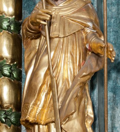 Zdjęcie nr 29: Nastawa ołtarzowa architektoniczna, trójosiowa z bramkami, dwukondygnacyjna, na dwustrefowym cokole. Ołtarz kamienny, prostopadłościenny, w drewnianej obudowie. Antepedium w formie wydłużonego, leżącego prostokąta, w polu obraz Ostatniej Wieczerzy. Mensa drewniana. Osie nastawy wydzielone parą półfilarów ujętych dwiema parami kolumn o kapitelach kompozytowych i skręconych trzonach. Dźwigają one pełne belkowanie silnie wyłamane na osi filarów, z mocno wysuniętym gzymsem, na skraju belkowania przerwany półkolisty przyczółek zwrócony na zewnątrz, na nim cokoły z figurami św. Władysława i św. Stefana. Na tle filarów ustawione figury św. Augustyna i św. Wojciecha, na bramkach rzeźby św. Marcina i św. Jana Jałmużnika. W polu głównym głęboka nisza w formie kwadratu zamkniętego łukiem falistym nadwieszonym, wewnątrz rzeźbiarska scena „Zabójstwa św. Stanisława”. Druga kondygnacja ujęta półfilarami, na tle których znajdują się anioły-kariatydy siedzące na cokołach z wolutami, podtrzymujące imposty. W polu prześwit w formie stojącego prostokąta z wpisanym krzyżem w kształcie litery „X”, przed którym znajduje się figura św. Andrzeja. Całość zwieńczona półpostacią Boga Ojca wśród obłoków i uskrzydlonych główek anielskich w glorii promienistej. Struktura obficie dekorowana ornamentem roślinnym, w partii pierwszej i drugiej kondygnacji uszy utworzone z akantu i wstęgi. Ołtarz flankują dodatkowo dwie pary wolnostojących półfilarów z półkolumnami o skręconych trzonach przed nimi, stojących na dwustrefowych cokołach, dźwigających imposty z figurami. Na zewnętrznej, niższej parze znajdują się figury św. Jana Ewangelisty i św. Jana Chrzciciela, na wewnętrznej, wyższej parze – św. Piotra i św. Pawła. Struktura polichromowana w sposób naśladujący marmoryzację w kolorze niebiesko-szarym, z zielonymi profilami oraz złoconymi kolumnami, profilami i ornamentyką.


