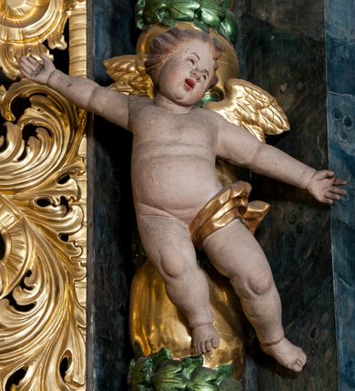 Zdjęcie nr 48: Nastawa ołtarzowa architektoniczna, trójosiowa z bramkami, dwukondygnacyjna, na dwustrefowym cokole. Ołtarz kamienny, prostopadłościenny, w drewnianej obudowie. Antepedium w formie wydłużonego, leżącego prostokąta, w polu obraz Ostatniej Wieczerzy. Mensa drewniana. Osie nastawy wydzielone parą półfilarów ujętych dwiema parami kolumn o kapitelach kompozytowych i skręconych trzonach. Dźwigają one pełne belkowanie silnie wyłamane na osi filarów, z mocno wysuniętym gzymsem, na skraju belkowania przerwany półkolisty przyczółek zwrócony na zewnątrz, na nim cokoły z figurami św. Władysława i św. Stefana. Na tle filarów ustawione figury św. Augustyna i św. Wojciecha, na bramkach rzeźby św. Marcina i św. Jana Jałmużnika. W polu głównym głęboka nisza w formie kwadratu zamkniętego łukiem falistym nadwieszonym, wewnątrz rzeźbiarska scena „Zabójstwa św. Stanisława”. Druga kondygnacja ujęta półfilarami, na tle których znajdują się anioły-kariatydy siedzące na cokołach z wolutami, podtrzymujące imposty. W polu prześwit w formie stojącego prostokąta z wpisanym krzyżem w kształcie litery „X”, przed którym znajduje się figura św. Andrzeja. Całość zwieńczona półpostacią Boga Ojca wśród obłoków i uskrzydlonych główek anielskich w glorii promienistej. Struktura obficie dekorowana ornamentem roślinnym, w partii pierwszej i drugiej kondygnacji uszy utworzone z akantu i wstęgi. Ołtarz flankują dodatkowo dwie pary wolnostojących półfilarów z półkolumnami o skręconych trzonach przed nimi, stojących na dwustrefowych cokołach, dźwigających imposty z figurami. Na zewnętrznej, niższej parze znajdują się figury św. Jana Ewangelisty i św. Jana Chrzciciela, na wewnętrznej, wyższej parze – św. Piotra i św. Pawła. Struktura polichromowana w sposób naśladujący marmoryzację w kolorze niebiesko-szarym, z zielonymi profilami oraz złoconymi kolumnami, profilami i ornamentyką.


