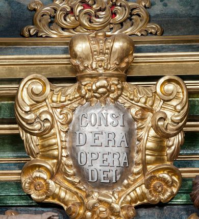 Zdjęcie nr 50: Nastawa ołtarzowa architektoniczna, trójosiowa z bramkami, dwukondygnacyjna, na dwustrefowym cokole. Ołtarz kamienny, prostopadłościenny, w drewnianej obudowie. Antepedium w formie wydłużonego, leżącego prostokąta, w polu obraz Ostatniej Wieczerzy. Mensa drewniana. Osie nastawy wydzielone parą półfilarów ujętych dwiema parami kolumn o kapitelach kompozytowych i skręconych trzonach. Dźwigają one pełne belkowanie silnie wyłamane na osi filarów, z mocno wysuniętym gzymsem, na skraju belkowania przerwany półkolisty przyczółek zwrócony na zewnątrz, na nim cokoły z figurami św. Władysława i św. Stefana. Na tle filarów ustawione figury św. Augustyna i św. Wojciecha, na bramkach rzeźby św. Marcina i św. Jana Jałmużnika. W polu głównym głęboka nisza w formie kwadratu zamkniętego łukiem falistym nadwieszonym, wewnątrz rzeźbiarska scena „Zabójstwa św. Stanisława”. Druga kondygnacja ujęta półfilarami, na tle których znajdują się anioły-kariatydy siedzące na cokołach z wolutami, podtrzymujące imposty. W polu prześwit w formie stojącego prostokąta z wpisanym krzyżem w kształcie litery „X”, przed którym znajduje się figura św. Andrzeja. Całość zwieńczona półpostacią Boga Ojca wśród obłoków i uskrzydlonych główek anielskich w glorii promienistej. Struktura obficie dekorowana ornamentem roślinnym, w partii pierwszej i drugiej kondygnacji uszy utworzone z akantu i wstęgi. Ołtarz flankują dodatkowo dwie pary wolnostojących półfilarów z półkolumnami o skręconych trzonach przed nimi, stojących na dwustrefowych cokołach, dźwigających imposty z figurami. Na zewnętrznej, niższej parze znajdują się figury św. Jana Ewangelisty i św. Jana Chrzciciela, na wewnętrznej, wyższej parze – św. Piotra i św. Pawła. Struktura polichromowana w sposób naśladujący marmoryzację w kolorze niebiesko-szarym, z zielonymi profilami oraz złoconymi kolumnami, profilami i ornamentyką.


