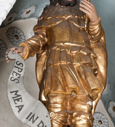 Zdjęcie nr 58: Nastawa ołtarzowa architektoniczna, trójosiowa z bramkami, dwukondygnacyjna, na dwustrefowym cokole. Ołtarz kamienny, prostopadłościenny, w drewnianej obudowie. Antepedium w formie wydłużonego, leżącego prostokąta, w polu obraz Ostatniej Wieczerzy. Mensa drewniana. Osie nastawy wydzielone parą półfilarów ujętych dwiema parami kolumn o kapitelach kompozytowych i skręconych trzonach. Dźwigają one pełne belkowanie silnie wyłamane na osi filarów, z mocno wysuniętym gzymsem, na skraju belkowania przerwany półkolisty przyczółek zwrócony na zewnątrz, na nim cokoły z figurami św. Władysława i św. Stefana. Na tle filarów ustawione figury św. Augustyna i św. Wojciecha, na bramkach rzeźby św. Marcina i św. Jana Jałmużnika. W polu głównym głęboka nisza w formie kwadratu zamkniętego łukiem falistym nadwieszonym, wewnątrz rzeźbiarska scena „Zabójstwa św. Stanisława”. Druga kondygnacja ujęta półfilarami, na tle których znajdują się anioły-kariatydy siedzące na cokołach z wolutami, podtrzymujące imposty. W polu prześwit w formie stojącego prostokąta z wpisanym krzyżem w kształcie litery „X”, przed którym znajduje się figura św. Andrzeja. Całość zwieńczona półpostacią Boga Ojca wśród obłoków i uskrzydlonych główek anielskich w glorii promienistej. Struktura obficie dekorowana ornamentem roślinnym, w partii pierwszej i drugiej kondygnacji uszy utworzone z akantu i wstęgi. Ołtarz flankują dodatkowo dwie pary wolnostojących półfilarów z półkolumnami o skręconych trzonach przed nimi, stojących na dwustrefowych cokołach, dźwigających imposty z figurami. Na zewnętrznej, niższej parze znajdują się figury św. Jana Ewangelisty i św. Jana Chrzciciela, na wewnętrznej, wyższej parze – św. Piotra i św. Pawła. Struktura polichromowana w sposób naśladujący marmoryzację w kolorze niebiesko-szarym, z zielonymi profilami oraz złoconymi kolumnami, profilami i ornamentyką.


