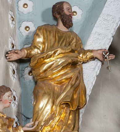 Zdjęcie nr 63: Nastawa ołtarzowa architektoniczna, trójosiowa z bramkami, dwukondygnacyjna, na dwustrefowym cokole. Ołtarz kamienny, prostopadłościenny, w drewnianej obudowie. Antepedium w formie wydłużonego, leżącego prostokąta, w polu obraz Ostatniej Wieczerzy. Mensa drewniana. Osie nastawy wydzielone parą półfilarów ujętych dwiema parami kolumn o kapitelach kompozytowych i skręconych trzonach. Dźwigają one pełne belkowanie silnie wyłamane na osi filarów, z mocno wysuniętym gzymsem, na skraju belkowania przerwany półkolisty przyczółek zwrócony na zewnątrz, na nim cokoły z figurami św. Władysława i św. Stefana. Na tle filarów ustawione figury św. Augustyna i św. Wojciecha, na bramkach rzeźby św. Marcina i św. Jana Jałmużnika. W polu głównym głęboka nisza w formie kwadratu zamkniętego łukiem falistym nadwieszonym, wewnątrz rzeźbiarska scena „Zabójstwa św. Stanisława”. Druga kondygnacja ujęta półfilarami, na tle których znajdują się anioły-kariatydy siedzące na cokołach z wolutami, podtrzymujące imposty. W polu prześwit w formie stojącego prostokąta z wpisanym krzyżem w kształcie litery „X”, przed którym znajduje się figura św. Andrzeja. Całość zwieńczona półpostacią Boga Ojca wśród obłoków i uskrzydlonych główek anielskich w glorii promienistej. Struktura obficie dekorowana ornamentem roślinnym, w partii pierwszej i drugiej kondygnacji uszy utworzone z akantu i wstęgi. Ołtarz flankują dodatkowo dwie pary wolnostojących półfilarów z półkolumnami o skręconych trzonach przed nimi, stojących na dwustrefowych cokołach, dźwigających imposty z figurami. Na zewnętrznej, niższej parze znajdują się figury św. Jana Ewangelisty i św. Jana Chrzciciela, na wewnętrznej, wyższej parze – św. Piotra i św. Pawła. Struktura polichromowana w sposób naśladujący marmoryzację w kolorze niebiesko-szarym, z zielonymi profilami oraz złoconymi kolumnami, profilami i ornamentyką.


