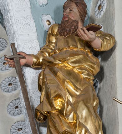 Zdjęcie nr 60: Nastawa ołtarzowa architektoniczna, trójosiowa z bramkami, dwukondygnacyjna, na dwustrefowym cokole. Ołtarz kamienny, prostopadłościenny, w drewnianej obudowie. Antepedium w formie wydłużonego, leżącego prostokąta, w polu obraz Ostatniej Wieczerzy. Mensa drewniana. Osie nastawy wydzielone parą półfilarów ujętych dwiema parami kolumn o kapitelach kompozytowych i skręconych trzonach. Dźwigają one pełne belkowanie silnie wyłamane na osi filarów, z mocno wysuniętym gzymsem, na skraju belkowania przerwany półkolisty przyczółek zwrócony na zewnątrz, na nim cokoły z figurami św. Władysława i św. Stefana. Na tle filarów ustawione figury św. Augustyna i św. Wojciecha, na bramkach rzeźby św. Marcina i św. Jana Jałmużnika. W polu głównym głęboka nisza w formie kwadratu zamkniętego łukiem falistym nadwieszonym, wewnątrz rzeźbiarska scena „Zabójstwa św. Stanisława”. Druga kondygnacja ujęta półfilarami, na tle których znajdują się anioły-kariatydy siedzące na cokołach z wolutami, podtrzymujące imposty. W polu prześwit w formie stojącego prostokąta z wpisanym krzyżem w kształcie litery „X”, przed którym znajduje się figura św. Andrzeja. Całość zwieńczona półpostacią Boga Ojca wśród obłoków i uskrzydlonych główek anielskich w glorii promienistej. Struktura obficie dekorowana ornamentem roślinnym, w partii pierwszej i drugiej kondygnacji uszy utworzone z akantu i wstęgi. Ołtarz flankują dodatkowo dwie pary wolnostojących półfilarów z półkolumnami o skręconych trzonach przed nimi, stojących na dwustrefowych cokołach, dźwigających imposty z figurami. Na zewnętrznej, niższej parze znajdują się figury św. Jana Ewangelisty i św. Jana Chrzciciela, na wewnętrznej, wyższej parze – św. Piotra i św. Pawła. Struktura polichromowana w sposób naśladujący marmoryzację w kolorze niebiesko-szarym, z zielonymi profilami oraz złoconymi kolumnami, profilami i ornamentyką.


