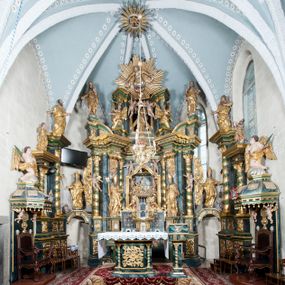 Zdjęcie nr 1: Nastawa ołtarzowa architektoniczna, trójosiowa z bramkami, dwukondygnacyjna, na dwustrefowym cokole. Ołtarz kamienny, prostopadłościenny, w drewnianej obudowie. Antepedium w formie wydłużonego, leżącego prostokąta, w polu obraz Ostatniej Wieczerzy. Mensa drewniana. Osie nastawy wydzielone parą półfilarów ujętych dwiema parami kolumn o kapitelach kompozytowych i skręconych trzonach. Dźwigają one pełne belkowanie silnie wyłamane na osi filarów, z mocno wysuniętym gzymsem, na skraju belkowania przerwany półkolisty przyczółek zwrócony na zewnątrz, na nim cokoły z figurami św. Władysława i św. Stefana. Na tle filarów ustawione figury św. Augustyna i św. Wojciecha, na bramkach rzeźby św. Marcina i św. Jana Jałmużnika. W polu głównym głęboka nisza w formie kwadratu zamkniętego łukiem falistym nadwieszonym, wewnątrz rzeźbiarska scena „Zabójstwa św. Stanisława”. Druga kondygnacja ujęta półfilarami, na tle których znajdują się anioły-kariatydy siedzące na cokołach z wolutami, podtrzymujące imposty. W polu prześwit w formie stojącego prostokąta z wpisanym krzyżem w kształcie litery „X”, przed którym znajduje się figura św. Andrzeja. Całość zwieńczona półpostacią Boga Ojca wśród obłoków i uskrzydlonych główek anielskich w glorii promienistej. Struktura obficie dekorowana ornamentem roślinnym, w partii pierwszej i drugiej kondygnacji uszy utworzone z akantu i wstęgi. Ołtarz flankują dodatkowo dwie pary wolnostojących półfilarów z półkolumnami o skręconych trzonach przed nimi, stojących na dwustrefowych cokołach, dźwigających imposty z figurami. Na zewnętrznej, niższej parze znajdują się figury św. Jana Ewangelisty i św. Jana Chrzciciela, na wewnętrznej, wyższej parze – św. Piotra i św. Pawła. Struktura polichromowana w sposób naśladujący marmoryzację w kolorze niebiesko-szarym, z zielonymi profilami oraz złoconymi kolumnami, profilami i ornamentyką.


