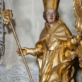 Zdjęcie nr 1: Figura ścięta z tyłu, stojąca na obłoku, ukazana frontalnie z głową zwróconą w lewą stronę, sylwetka esowato wygięta, ręce rozchylone na boki, w prawej trzyma pastorał. Twarz świętego owalna, pełna, oczy skierowane ku górze, usta lekko rozchylone, okolona krótkimi, falowanymi włosami, sięgającymi ramion. Marcin jest ubrany w szaty biskupie: albę, rokietę i mucet, na głowie ma infułę, na piersi zawieszony pektorał, na dłoniach rękawiczki. Ramiona okrywa kapa spięta na piersi, z rozwianą fałdą przy jego lewym boku. Obok świętego, po jego prawej, półpostać zwrócona w trzech czwartych w prawo, z rękoma złożonymi w geście modlitwy. Szaty postaci złocone, karnacja ciała w odcieniu jasnokremowym. 