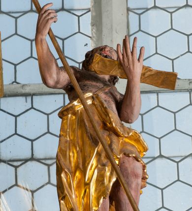 Zdjęcie nr 1: Rzeźba stoi na podstawie w formie obłoku, zwrócona jest frontalnie, z tułowiem silnie odchylonym w tył i lewą nogą wspartą na obłoku. Święty ma obie ręce uniesione w górę, w prawej trzyma laskę zakończoną krzyżem, a na lewej dłoni ma rozpostarty pergamin. Jego twarz jest pociągła, z szeroko otwartymi oczami skierowanymi w górę, okolona brodą i krótkimi włosami. Święty ubrany jest w melotę (płaszcz ze skóry wielbłądziej) zawieszoną na pasku na lewym ramieniu, opadającą na prawy bok i tył postaci, odsłaniając klatkę piersiową. Polichromia naturalistyczna w partii ciała, szaty i atrybuty pozłocone. 