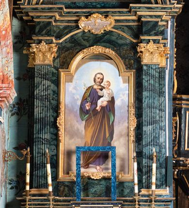 Zdjęcie nr 7: Nastawa architektoniczna, jednoosiowa, jednokondygnacyjna ze zwieńczeniem. Ołtarz prostopadłościenny, murowany, w drewnianej obudowie, z kamienną mensą. Antepedium ujęte profilowaną ramą, w polu malowana płycina w formie leżącego prostokąta o wklęsłych narożach, wypełniona różami, z akantowym kartuszem w centrum. W narożach przedstawienia ptaków na gałęziach. W polu kartusza scena męczeństwa św Wita, na tle pejzażu. Retabulum ustawione na dwustrefowym cokole, z wyłamanymi dwoma prostopadłościanami, w górnej części dekorowanymi rocaille'owymi płycinami. Nastawa ujęta parą zdwojonych pilastrów, o kanelowanych trzonach i kapitelach kompozytowych, dźwigających pełne belkowanie, wyłamane na ich osi, z architrawem przyjmującym nad polem środkowym formę łuku odcinkowego oraz fragmenty półkolistego, przerwanego przyczółka. W polu centralnym wnęka w kształcie stojącego prostokąta zamkniętego łukiem półkolistym nadwieszonym, ujęta profilowaną ramą, z obrazem św. Józefa z Dzieciątkiem. Nad nią, w polu belkowania rocaille'owy kartusz z napisem „QUIA VIRGO ELECTUS / VIRGO IN AEVUM / PERMANSIT”. Zwieńczenie w formie zbliżonej do trapezu, ujętego spływami wolutowymi, zamkniętego fragmentem gzymsu w formie łuku półkolistego nadwieszonego. Zwieńczenie zakończone rokokową muszlą i rocaille'm, flankowane kampanulami. W polu obraz św. Floriana w kształcie analogicznym do zwieńczenia, w profilowanej ramie. Struktura polichromowana na sposób imitujący marmoryzację w kolorach niebieskim i zielonym, profile i ornamentyka złocone, detal srebrzony. 



