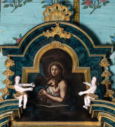 Zdjęcie nr 3: Nastawa architektoniczna, jednoosiowa, jednokondygnacyjna ze zwieńczeniem. Ołtarz prostopadłościenny, murowany, w drewnianej obudowie, z kamienną mensą. Antepedium ujęte profilowaną ramą, w polu malowana płycina w formie leżącego prostokąta o wklęsłych narożach, wypełniona różami, z akantowym kartuszem w centrum. W narożach przedstawienia ptaków na gałęziach. W polu kartusza scena ścięcia św. Barbary przez oprawcę, na tle pejzażu. Retabulum ustawione na dwustrefowym cokole, z wyłamanymi dwoma prostopadłościanami, w górnej części dekorowanym rocaille'owymi płycinami. Nastawa ujęta parą zdwojonych pilastrów, o kanelowanych trzonach i kapitelach kompozytowych, dźwigających pełne belkowanie, wyłamane na ich osi, z architrawem przyjmującym nad polem środkowym formę łuku odcinkowego oraz fragmenty półkolistego, przerwanego przyczółka. W polu centralnym wnęka w kształcie stojącego prostokąta zamkniętego łukiem półkolistym nadwieszonym, ujęta profilowaną ramą, z obrazem św. Barbary. Nad nią, w polu belkowania rocaille'owy kartusz z napisem „IT DE / NOCTE SURREXIT DEDIT / CIBARIA ANCIRIS / SUIS”. Zwieńczenie w formie zbliżonej do trapezu, ujętego spływami wolutowymi, zamkniętego fragmentem gzymsu w kształcie łuku półkolistego nadwieszonego. Zwieńczenie zakończone rokokową muszlą i rocaille'm, flankowane kampanulami. W polu obraz pokutującej św. Marii Magdaleny w kształcie analogicznym do zwieńczenia, w profilowanej ramie. Struktura polichromowana na sposób imitujący marmoryzację w kolorach niebieskim i zielonym, profile i ornamentyka złocone, detal srebrzony. 




