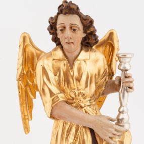 Zdjęcie nr 1: Pełnoplastyczne figury klęczących na jedno kolano aniołów, ustawionych na niskich podstawach. Postacie ukazane są z profilu, z głowami skierowanymi frontalnie. Na ugiętych kolanach trzymają srebrzone lichtarze, przytrzymując je obiema rękami, z boku i od spodu. Twarze mają podłużne, trójkątne, o dużych, migdałowatych, opadających oczach, prostych nosach i wąskich ustach, okolone silnie kręconymi włosami, układającymi się po bokach głowy, a nad czołem tworzące czub. Ubrane są w długie ciemnoczerwone suknie spodnie i złocone suknie wierzchnie z kołnierzykami, sięgające kolan, z podwiniętymi rękawami, przepasane w talii szarfami. Skrzydła mają małe, złocone, złożone po bokach postaci. Polichromia ciała naturalistyczna. 



