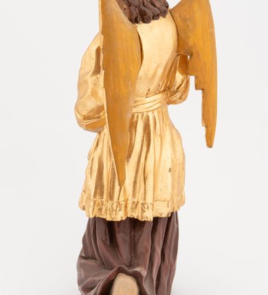 Zdjęcie nr 8: Pełnoplastyczne figury klęczących na jedno kolano aniołów, ustawionych na niskich podstawach. Postacie ukazane są z profilu, z głowami skierowanymi frontalnie. Na ugiętych kolanach trzymają srebrzone lichtarze, przytrzymując je obiema rękami, z boku i od spodu. Twarze mają podłużne, trójkątne, o dużych, migdałowatych, opadających oczach, prostych nosach i wąskich ustach, okolone silnie kręconymi włosami, układającymi się po bokach głowy, a nad czołem tworzące czub. Ubrane są w długie ciemnoczerwone suknie spodnie i złocone suknie wierzchnie z kołnierzykami, sięgające kolan, z podwiniętymi rękawami, przepasane w talii szarfami. Skrzydła mają małe, złocone, złożone po bokach postaci. Polichromia ciała naturalistyczna. 



