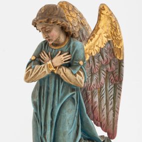 Zdjęcie nr 1: Pełnoplastyczne figury aniołów, klęczących na podstawach i poduszkach z chwostami. Postacie ukazane z profilu, z pochylonymi głowami, jedna ma skrzyżowane na piersi ręce, druga złożone w geście modlitwy. Twarze mają szczupłe, trójkątne, z oczami skierowanymi w dół, prostymi nosami i wąskimi ustami, okolone jasnobrązowymi, kręconymi włosami, opadającymi na kark. Ubrane są w jasnożółte szaty spodnie, z długimi rękawami, o złoconych lamówkach oraz jasnoniebieskie szaty wierzchnie, z krótkimi rękawami i złoconymi lamówkami. Skrzydła mają duże, złożone na plecach, złocone przy górnym brzegu, polichromowane w kolorach szarym i różowym w dolnej części. Polichromia ciał naturalistyczna. 

