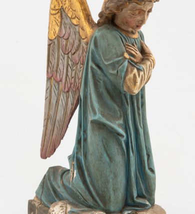 Zdjęcie nr 6: Pełnoplastyczne figury aniołów, klęczących na podstawach i poduszkach z chwostami. Postacie ukazane z profilu, z pochylonymi głowami, jedna ma skrzyżowane na piersi ręce, druga złożone w geście modlitwy. Twarze mają szczupłe, trójkątne, z oczami skierowanymi w dół, prostymi nosami i wąskimi ustami, okolone jasnobrązowymi, kręconymi włosami, opadającymi na kark. Ubrane są w jasnożółte szaty spodnie, z długimi rękawami, o złoconych lamówkach oraz jasnoniebieskie szaty wierzchnie, z krótkimi rękawami i złoconymi lamówkami. Skrzydła mają duże, złożone na plecach, złocone przy górnym brzegu, polichromowane w kolorach szarym i różowym w dolnej części. Polichromia ciał naturalistyczna. 

