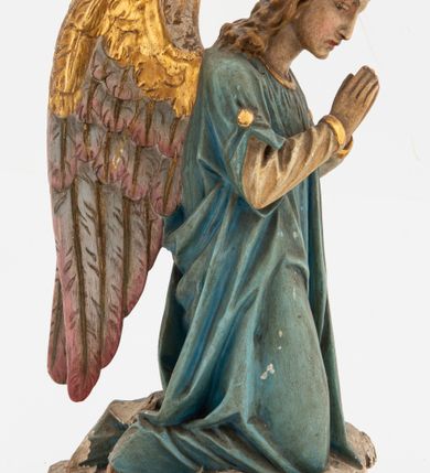 Zdjęcie nr 11: Pełnoplastyczne figury aniołów, klęczących na podstawach i poduszkach z chwostami. Postacie ukazane z profilu, z pochylonymi głowami, jedna ma skrzyżowane na piersi ręce, druga złożone w geście modlitwy. Twarze mają szczupłe, trójkątne, z oczami skierowanymi w dół, prostymi nosami i wąskimi ustami, okolone jasnobrązowymi, kręconymi włosami, opadającymi na kark. Ubrane są w jasnożółte szaty spodnie, z długimi rękawami, o złoconych lamówkach oraz jasnoniebieskie szaty wierzchnie, z krótkimi rękawami i złoconymi lamówkami. Skrzydła mają duże, złożone na plecach, złocone przy górnym brzegu, polichromowane w kolorach szarym i różowym w dolnej części. Polichromia ciał naturalistyczna. 

