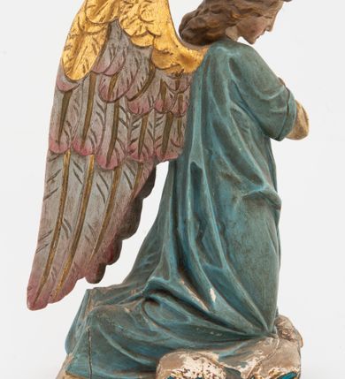 Zdjęcie nr 7: Pełnoplastyczne figury aniołów, klęczących na podstawach i poduszkach z chwostami. Postacie ukazane z profilu, z pochylonymi głowami, jedna ma skrzyżowane na piersi ręce, druga złożone w geście modlitwy. Twarze mają szczupłe, trójkątne, z oczami skierowanymi w dół, prostymi nosami i wąskimi ustami, okolone jasnobrązowymi, kręconymi włosami, opadającymi na kark. Ubrane są w jasnożółte szaty spodnie, z długimi rękawami, o złoconych lamówkach oraz jasnoniebieskie szaty wierzchnie, z krótkimi rękawami i złoconymi lamówkami. Skrzydła mają duże, złożone na plecach, złocone przy górnym brzegu, polichromowane w kolorach szarym i różowym w dolnej części. Polichromia ciał naturalistyczna. 

