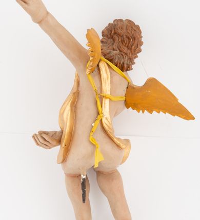 Zdjęcie nr 4: Dwie pełnoplastyczne rzeźby siedzących aniołów, ukazanych frontalnie, przechylonych w bok, z obiema rękami wyciągniętymi w przeciwną stronę. Twarze mają wydłużone, o pełnych policzkach, migdałowatych, dużych oczach, krótkich nosach i wąskich ustach, okolone krótkimi, kręconymi włosami. W partii bioder przewiązane złoconą tkaniną, zawiniętą na jednym ramieniu. Ciała mają pulchne, o nieproporcjonalnych względem korpusu kończynach. Ich skrzydła są złocone, małe i rozłożone na boki. Polichromia ciała naturalistyczna.