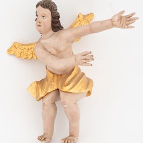 Zdjęcie nr 1: Dwie pełnoplastyczne rzeźby siedzących aniołów, ukazanych frontalnie, pochylonych w bok, z obiema rękami wyciągniętymi w bok. Twarze mają wydłużone, o pełnych policzkach, migdałowatych, dużych oczach, prostych nosach i wąskich ustach, okolone kręconymi włosami, opadającymi na tył głowy. W partii bioder przewiązane złoconą tkaniną. Ciała mają pulchne, o nieproporcjonalnych względem korpusu kończynach. Ich skrzydła są złocone, małe i rozłożone na boki. Polichromia ciała naturalistyczna.
