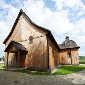 Zdjęcie nr 1: Kościół drewniany o konstrukcji zrębowej, na betonowym podmurowaniu przesłoniętym daszkiem gontowym. Elewacje jednolite, szalowane z listwowaniem, wzmocnione lisicami. Więźba dachowa drewniana, krokwiowa, o systemie więźbowo-zaskrzynieniowym. Kościół orientowany, jednonawowy, nawa na rzucie wydłużonego prostokąta, prezbiterium nieco węższe, zakończone trójbocznie. Do północnej ściany prezbiterium i nawy przylega zakrystia połączona z aneksem na rzucie prostokąta, do nawy od południa przylega duża kaplica na planie prostokąta otwarta do nawy otworem o wykroju prostokąta zamkniętego łukiem odcinkowym. 
Ściany wnętrza podzielone trzema parami pilastrów. Pomiędzy nawą a prezbiterium arkadowy otwór tęczowy z prostą belką. Parapet chóru muzycznego w zachodniej części nawy, oparty na dwóch kolumnach o wielobocznych trzonach. Wnętrze nakryte stropem płaskim, w nawie z zaskrzynieniami podtrzymywanymi przez trzy pary słupów o wielobocznych i kręconych trzonach. Otwory drzwiowe o prostokątnym wykroju zamknięte drzwiami jednoskrzydłowymi w północnej ścianie nawy oraz prezbiterium. Posadzka z płyt kamiennych. 
Elewacja frontowa jednoosiowa, zamknięta trójkątnym szczytem rozszerzającym się ku dołowi. Na osi ganek oparty na czterech słupach, nakryty dwuspadowym daszkiem gontowym, wejście do kościoła z dwuskrzydłowymi drzwiami. W partii szczytu dwa okna w formie stojącego prostokąta zamkniętego łukiem półkolistym. W elewacji południowej cztery otwory okienne w formie stojącego prostokąta zamkniętego łukiem półkolistym, dwa w nawie i dwa w prezbiterium oraz dwa analogiczne okna na zachodniej i wschodniej ścianie kaplicy. Elewacja północna z dwoma otworami okiennymi w formie stojącego prostokąta zamkniętego łukiem półkolistym, trzema oknami i wejściem do zakrystii i aneksu. Kościół nakryty wspólnym dachem o jednej kalenicy nad prezbiterium i nawą, gontowym, dwuspadowym, z przedłużoną połacią przekrywającą zaskrzynienia. W jednej trzeciej długości dachu nad nawą od strony prezbiterium wznosi się ponad kalenicą wieżyczka na sygnaturkę, na ośmiobocznym obitym blachą trzonie, z latarnią zwieńczoną niewielkim cebulastym hełmem. Kaplica boczna nakryta kopułą krytą gontem, z latarnią. Nad zakrystią i aneksem dach jednospadowy.
 
