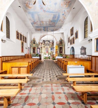 Zdjęcie nr 4: Kościół murowany z cegły i kamienia, tynkowany. Detal architektoniczny kamienny i rzeźbiony w tynku. Więźba dachowa drewniana, krokwiowa. Świątynia orientowana, jednonawowa, nawa na rzucie wydłużonego prostokąta, prezbiterium nieco węższe, zakończone wielobocznie, z wieżą na planie kwadratu. Do prezbiterium od północy przylega zakrystia z przedsionkiem i kruchtą na planie zbliżonym do prostokąta, do nawy od południa przybudowana kaplica na rzucie ośmioboku oraz od północy kruchta na planie kwadratu. Całość oszkarpowana. Wnętrze nakryte drewnianymi stropami i sufitami z wyprawą tynkową i polichromią. Pomiędzy nawą a prezbiterium półkolisty otwór tęczowy. Parapet chóru muzycznego w zachodniej części nawy, podparty na dwóch kolumnach. Otwory drzwiowe o wykroju prostokątnym, ostrołukowym i prostokątnym zamkniętym łukiem segmentowym. Drzwi drewniane obite listwami i płycinowe. Okna w formie stojącego prostokąta zamkniętego łukiem półkolistym, w wieży zamknięte łukiem ostrym, w metalowej oprawie, witrażowe. Posadzka z płyt ceramicznych. Elewacje opracowane jednolicie, tynkowane, zakończone gzymsem podokapowym, opięte dwuuskokowymi szkarpami. Elewacja zachodnia wieżowa, jednoosiowa, czterokondygnacyjna, z wydzielonym cokołem. Kondygnacje wydzielone gzymsami kordonowymi, ostatnia na planie ośmioboku. Na osi ostrołukowy portal z profilowanym obramieniem w tynku. Drzwi drewniane dwuskrzydłowe, obite listwami, z ostrołukowym naświetlem. Nad portalem owalna tablica fundacyjna z napisem „WIEŻA TA WYBUDOWANA / NA CZEŚĆ / MATKI BOSKIEJ / R(OKU) P(AŃSKIEGO) 1888”. Na froncie wieży, na osi, dwa ostrołukowe okna, na ścianach bocznych po trzy ostrołukowe okna, w najwyższej partii rząd okulusów. Wieża zakończona ośmioma trójkątnymi szczytami i ostrosłupowym hełmem z metalową koroną. Elewacje boczne przeprute oknami, po dwa w nawie i prezbiterium, alternowanymi szkarpami. W kaplicy i w zakrystii po dwa okna. Elewacja wschodnia pozbawiona okien. Kruchta północna przybudowana do korpusu, od frontu ujęta stylizowanymi półkolumnami dźwigającymi wklęsło-wypukły szczyt. W zewnętrzne ściany kościoła wmurowane współczesne, ceramiczne stacje drogi krzyżowej. Dachy dwuspadowe, kryte dachówką ceramiczną. Wyższy nad nawą, niższy nad prezbiterium. W połowie długości dachu, nad nawą, wieżyczka na sygnaturkę z latarnią, zwieńczona ostrosłupowym hełmem. Nad zakrystią ceramiczny dach pulpitowy, nad kruchtą dwuspadowy, nad kaplicą ostrosłupowy, kryty blachą. 