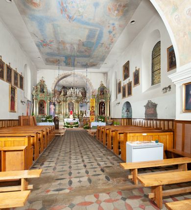 Zdjęcie nr 7: Kościół murowany z cegły i kamienia, tynkowany. Detal architektoniczny kamienny i rzeźbiony w tynku. Więźba dachowa drewniana, krokwiowa. Świątynia orientowana, jednonawowa, nawa na rzucie wydłużonego prostokąta, prezbiterium nieco węższe, zakończone wielobocznie, z wieżą na planie kwadratu. Do prezbiterium od północy przylega zakrystia z przedsionkiem i kruchtą na planie zbliżonym do prostokąta, do nawy od południa przybudowana kaplica na rzucie ośmioboku oraz od północy kruchta na planie kwadratu. Całość oszkarpowana. Wnętrze nakryte drewnianymi stropami i sufitami z wyprawą tynkową i polichromią. Pomiędzy nawą a prezbiterium półkolisty otwór tęczowy. Parapet chóru muzycznego w zachodniej części nawy, podparty na dwóch kolumnach. Otwory drzwiowe o wykroju prostokątnym, ostrołukowym i prostokątnym zamkniętym łukiem segmentowym. Drzwi drewniane obite listwami i płycinowe. Okna w formie stojącego prostokąta zamkniętego łukiem półkolistym, w wieży zamknięte łukiem ostrym, w metalowej oprawie, witrażowe. Posadzka z płyt ceramicznych. Elewacje opracowane jednolicie, tynkowane, zakończone gzymsem podokapowym, opięte dwuuskokowymi szkarpami. Elewacja zachodnia wieżowa, jednoosiowa, czterokondygnacyjna, z wydzielonym cokołem. Kondygnacje wydzielone gzymsami kordonowymi, ostatnia na planie ośmioboku. Na osi ostrołukowy portal z profilowanym obramieniem w tynku. Drzwi drewniane dwuskrzydłowe, obite listwami, z ostrołukowym naświetlem. Nad portalem owalna tablica fundacyjna z napisem „WIEŻA TA WYBUDOWANA / NA CZEŚĆ / MATKI BOSKIEJ / R(OKU) P(AŃSKIEGO) 1888”. Na froncie wieży, na osi, dwa ostrołukowe okna, na ścianach bocznych po trzy ostrołukowe okna, w najwyższej partii rząd okulusów. Wieża zakończona ośmioma trójkątnymi szczytami i ostrosłupowym hełmem z metalową koroną. Elewacje boczne przeprute oknami, po dwa w nawie i prezbiterium, alternowanymi szkarpami. W kaplicy i w zakrystii po dwa okna. Elewacja wschodnia pozbawiona okien. Kruchta północna przybudowana do korpusu, od frontu ujęta stylizowanymi półkolumnami dźwigającymi wklęsło-wypukły szczyt. W zewnętrzne ściany kościoła wmurowane współczesne, ceramiczne stacje drogi krzyżowej. Dachy dwuspadowe, kryte dachówką ceramiczną. Wyższy nad nawą, niższy nad prezbiterium. W połowie długości dachu, nad nawą, wieżyczka na sygnaturkę z latarnią, zwieńczona ostrosłupowym hełmem. Nad zakrystią ceramiczny dach pulpitowy, nad kruchtą dwuspadowy, nad kaplicą ostrosłupowy, kryty blachą. 