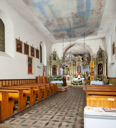 Zdjęcie nr 8: Kościół murowany z cegły i kamienia, tynkowany. Detal architektoniczny kamienny i rzeźbiony w tynku. Więźba dachowa drewniana, krokwiowa. Świątynia orientowana, jednonawowa, nawa na rzucie wydłużonego prostokąta, prezbiterium nieco węższe, zakończone wielobocznie, z wieżą na planie kwadratu. Do prezbiterium od północy przylega zakrystia z przedsionkiem i kruchtą na planie zbliżonym do prostokąta, do nawy od południa przybudowana kaplica na rzucie ośmioboku oraz od północy kruchta na planie kwadratu. Całość oszkarpowana. Wnętrze nakryte drewnianymi stropami i sufitami z wyprawą tynkową i polichromią. Pomiędzy nawą a prezbiterium półkolisty otwór tęczowy. Parapet chóru muzycznego w zachodniej części nawy, podparty na dwóch kolumnach. Otwory drzwiowe o wykroju prostokątnym, ostrołukowym i prostokątnym zamkniętym łukiem segmentowym. Drzwi drewniane obite listwami i płycinowe. Okna w formie stojącego prostokąta zamkniętego łukiem półkolistym, w wieży zamknięte łukiem ostrym, w metalowej oprawie, witrażowe. Posadzka z płyt ceramicznych. Elewacje opracowane jednolicie, tynkowane, zakończone gzymsem podokapowym, opięte dwuuskokowymi szkarpami. Elewacja zachodnia wieżowa, jednoosiowa, czterokondygnacyjna, z wydzielonym cokołem. Kondygnacje wydzielone gzymsami kordonowymi, ostatnia na planie ośmioboku. Na osi ostrołukowy portal z profilowanym obramieniem w tynku. Drzwi drewniane dwuskrzydłowe, obite listwami, z ostrołukowym naświetlem. Nad portalem owalna tablica fundacyjna z napisem „WIEŻA TA WYBUDOWANA / NA CZEŚĆ / MATKI BOSKIEJ / R(OKU) P(AŃSKIEGO) 1888”. Na froncie wieży, na osi, dwa ostrołukowe okna, na ścianach bocznych po trzy ostrołukowe okna, w najwyższej partii rząd okulusów. Wieża zakończona ośmioma trójkątnymi szczytami i ostrosłupowym hełmem z metalową koroną. Elewacje boczne przeprute oknami, po dwa w nawie i prezbiterium, alternowanymi szkarpami. W kaplicy i w zakrystii po dwa okna. Elewacja wschodnia pozbawiona okien. Kruchta północna przybudowana do korpusu, od frontu ujęta stylizowanymi półkolumnami dźwigającymi wklęsło-wypukły szczyt. W zewnętrzne ściany kościoła wmurowane współczesne, ceramiczne stacje drogi krzyżowej. Dachy dwuspadowe, kryte dachówką ceramiczną. Wyższy nad nawą, niższy nad prezbiterium. W połowie długości dachu, nad nawą, wieżyczka na sygnaturkę z latarnią, zwieńczona ostrosłupowym hełmem. Nad zakrystią ceramiczny dach pulpitowy, nad kruchtą dwuspadowy, nad kaplicą ostrosłupowy, kryty blachą. 