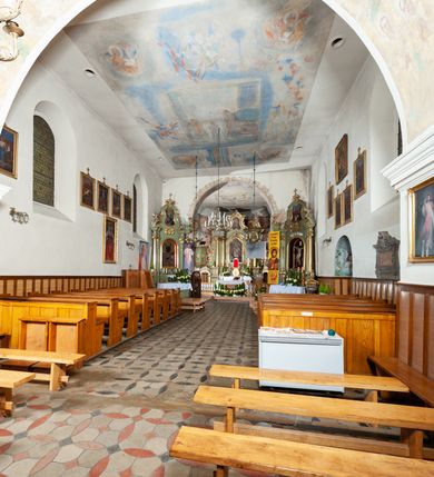 Zdjęcie nr 9: Kościół murowany z cegły i kamienia, tynkowany. Detal architektoniczny kamienny i rzeźbiony w tynku. Więźba dachowa drewniana, krokwiowa. Świątynia orientowana, jednonawowa, nawa na rzucie wydłużonego prostokąta, prezbiterium nieco węższe, zakończone wielobocznie, z wieżą na planie kwadratu. Do prezbiterium od północy przylega zakrystia z przedsionkiem i kruchtą na planie zbliżonym do prostokąta, do nawy od południa przybudowana kaplica na rzucie ośmioboku oraz od północy kruchta na planie kwadratu. Całość oszkarpowana. Wnętrze nakryte drewnianymi stropami i sufitami z wyprawą tynkową i polichromią. Pomiędzy nawą a prezbiterium półkolisty otwór tęczowy. Parapet chóru muzycznego w zachodniej części nawy, podparty na dwóch kolumnach. Otwory drzwiowe o wykroju prostokątnym, ostrołukowym i prostokątnym zamkniętym łukiem segmentowym. Drzwi drewniane obite listwami i płycinowe. Okna w formie stojącego prostokąta zamkniętego łukiem półkolistym, w wieży zamknięte łukiem ostrym, w metalowej oprawie, witrażowe. Posadzka z płyt ceramicznych. Elewacje opracowane jednolicie, tynkowane, zakończone gzymsem podokapowym, opięte dwuuskokowymi szkarpami. Elewacja zachodnia wieżowa, jednoosiowa, czterokondygnacyjna, z wydzielonym cokołem. Kondygnacje wydzielone gzymsami kordonowymi, ostatnia na planie ośmioboku. Na osi ostrołukowy portal z profilowanym obramieniem w tynku. Drzwi drewniane dwuskrzydłowe, obite listwami, z ostrołukowym naświetlem. Nad portalem owalna tablica fundacyjna z napisem „WIEŻA TA WYBUDOWANA / NA CZEŚĆ / MATKI BOSKIEJ / R(OKU) P(AŃSKIEGO) 1888”. Na froncie wieży, na osi, dwa ostrołukowe okna, na ścianach bocznych po trzy ostrołukowe okna, w najwyższej partii rząd okulusów. Wieża zakończona ośmioma trójkątnymi szczytami i ostrosłupowym hełmem z metalową koroną. Elewacje boczne przeprute oknami, po dwa w nawie i prezbiterium, alternowanymi szkarpami. W kaplicy i w zakrystii po dwa okna. Elewacja wschodnia pozbawiona okien. Kruchta północna przybudowana do korpusu, od frontu ujęta stylizowanymi półkolumnami dźwigającymi wklęsło-wypukły szczyt. W zewnętrzne ściany kościoła wmurowane współczesne, ceramiczne stacje drogi krzyżowej. Dachy dwuspadowe, kryte dachówką ceramiczną. Wyższy nad nawą, niższy nad prezbiterium. W połowie długości dachu, nad nawą, wieżyczka na sygnaturkę z latarnią, zwieńczona ostrosłupowym hełmem. Nad zakrystią ceramiczny dach pulpitowy, nad kruchtą dwuspadowy, nad kaplicą ostrosłupowy, kryty blachą. 