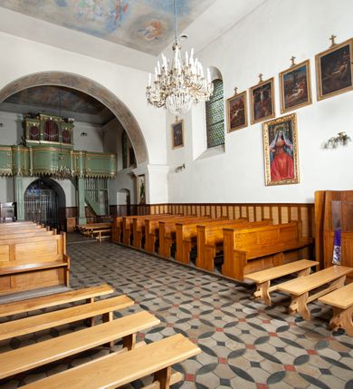 Zdjęcie nr 16: Kościół murowany z cegły i kamienia, tynkowany. Detal architektoniczny kamienny i rzeźbiony w tynku. Więźba dachowa drewniana, krokwiowa. Świątynia orientowana, jednonawowa, nawa na rzucie wydłużonego prostokąta, prezbiterium nieco węższe, zakończone wielobocznie, z wieżą na planie kwadratu. Do prezbiterium od północy przylega zakrystia z przedsionkiem i kruchtą na planie zbliżonym do prostokąta, do nawy od południa przybudowana kaplica na rzucie ośmioboku oraz od północy kruchta na planie kwadratu. Całość oszkarpowana. Wnętrze nakryte drewnianymi stropami i sufitami z wyprawą tynkową i polichromią. Pomiędzy nawą a prezbiterium półkolisty otwór tęczowy. Parapet chóru muzycznego w zachodniej części nawy, podparty na dwóch kolumnach. Otwory drzwiowe o wykroju prostokątnym, ostrołukowym i prostokątnym zamkniętym łukiem segmentowym. Drzwi drewniane obite listwami i płycinowe. Okna w formie stojącego prostokąta zamkniętego łukiem półkolistym, w wieży zamknięte łukiem ostrym, w metalowej oprawie, witrażowe. Posadzka z płyt ceramicznych. Elewacje opracowane jednolicie, tynkowane, zakończone gzymsem podokapowym, opięte dwuuskokowymi szkarpami. Elewacja zachodnia wieżowa, jednoosiowa, czterokondygnacyjna, z wydzielonym cokołem. Kondygnacje wydzielone gzymsami kordonowymi, ostatnia na planie ośmioboku. Na osi ostrołukowy portal z profilowanym obramieniem w tynku. Drzwi drewniane dwuskrzydłowe, obite listwami, z ostrołukowym naświetlem. Nad portalem owalna tablica fundacyjna z napisem „WIEŻA TA WYBUDOWANA / NA CZEŚĆ / MATKI BOSKIEJ / R(OKU) P(AŃSKIEGO) 1888”. Na froncie wieży, na osi, dwa ostrołukowe okna, na ścianach bocznych po trzy ostrołukowe okna, w najwyższej partii rząd okulusów. Wieża zakończona ośmioma trójkątnymi szczytami i ostrosłupowym hełmem z metalową koroną. Elewacje boczne przeprute oknami, po dwa w nawie i prezbiterium, alternowanymi szkarpami. W kaplicy i w zakrystii po dwa okna. Elewacja wschodnia pozbawiona okien. Kruchta północna przybudowana do korpusu, od frontu ujęta stylizowanymi półkolumnami dźwigającymi wklęsło-wypukły szczyt. W zewnętrzne ściany kościoła wmurowane współczesne, ceramiczne stacje drogi krzyżowej. Dachy dwuspadowe, kryte dachówką ceramiczną. Wyższy nad nawą, niższy nad prezbiterium. W połowie długości dachu, nad nawą, wieżyczka na sygnaturkę z latarnią, zwieńczona ostrosłupowym hełmem. Nad zakrystią ceramiczny dach pulpitowy, nad kruchtą dwuspadowy, nad kaplicą ostrosłupowy, kryty blachą. 