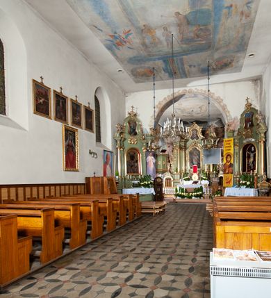 Zdjęcie nr 11: Kościół murowany z cegły i kamienia, tynkowany. Detal architektoniczny kamienny i rzeźbiony w tynku. Więźba dachowa drewniana, krokwiowa. Świątynia orientowana, jednonawowa, nawa na rzucie wydłużonego prostokąta, prezbiterium nieco węższe, zakończone wielobocznie, z wieżą na planie kwadratu. Do prezbiterium od północy przylega zakrystia z przedsionkiem i kruchtą na planie zbliżonym do prostokąta, do nawy od południa przybudowana kaplica na rzucie ośmioboku oraz od północy kruchta na planie kwadratu. Całość oszkarpowana. Wnętrze nakryte drewnianymi stropami i sufitami z wyprawą tynkową i polichromią. Pomiędzy nawą a prezbiterium półkolisty otwór tęczowy. Parapet chóru muzycznego w zachodniej części nawy, podparty na dwóch kolumnach. Otwory drzwiowe o wykroju prostokątnym, ostrołukowym i prostokątnym zamkniętym łukiem segmentowym. Drzwi drewniane obite listwami i płycinowe. Okna w formie stojącego prostokąta zamkniętego łukiem półkolistym, w wieży zamknięte łukiem ostrym, w metalowej oprawie, witrażowe. Posadzka z płyt ceramicznych. Elewacje opracowane jednolicie, tynkowane, zakończone gzymsem podokapowym, opięte dwuuskokowymi szkarpami. Elewacja zachodnia wieżowa, jednoosiowa, czterokondygnacyjna, z wydzielonym cokołem. Kondygnacje wydzielone gzymsami kordonowymi, ostatnia na planie ośmioboku. Na osi ostrołukowy portal z profilowanym obramieniem w tynku. Drzwi drewniane dwuskrzydłowe, obite listwami, z ostrołukowym naświetlem. Nad portalem owalna tablica fundacyjna z napisem „WIEŻA TA WYBUDOWANA / NA CZEŚĆ / MATKI BOSKIEJ / R(OKU) P(AŃSKIEGO) 1888”. Na froncie wieży, na osi, dwa ostrołukowe okna, na ścianach bocznych po trzy ostrołukowe okna, w najwyższej partii rząd okulusów. Wieża zakończona ośmioma trójkątnymi szczytami i ostrosłupowym hełmem z metalową koroną. Elewacje boczne przeprute oknami, po dwa w nawie i prezbiterium, alternowanymi szkarpami. W kaplicy i w zakrystii po dwa okna. Elewacja wschodnia pozbawiona okien. Kruchta północna przybudowana do korpusu, od frontu ujęta stylizowanymi półkolumnami dźwigającymi wklęsło-wypukły szczyt. W zewnętrzne ściany kościoła wmurowane współczesne, ceramiczne stacje drogi krzyżowej. Dachy dwuspadowe, kryte dachówką ceramiczną. Wyższy nad nawą, niższy nad prezbiterium. W połowie długości dachu, nad nawą, wieżyczka na sygnaturkę z latarnią, zwieńczona ostrosłupowym hełmem. Nad zakrystią ceramiczny dach pulpitowy, nad kruchtą dwuspadowy, nad kaplicą ostrosłupowy, kryty blachą. 