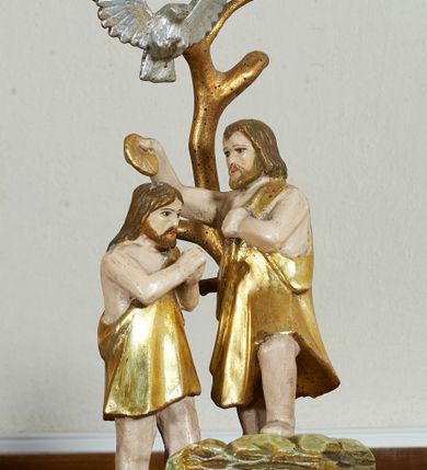 Zdjęcie nr 1: Chrzcielnica na masywnej kamiennej podstawie na planie ściętego koła. Trzon z piaskowca, polichromowany na sposób imitujący marmoryzację, w formie jednolalkowej tralki z okrągłą plintą i sześcienną bazą. Czara marmurowa w formie spłaszczonej półkuli, z wywiniętym brzegiem, ujęta metalowymi cęgami z kotwami. Wewnątrz blaszana misa. 
Pokrywa drewniana, na profilowanej podstawie na planie ośmioboku, w formie kopułki pokrytej łuską, podzielonej na osiem pól, zwieńczona cokołem z niewielką grupą rzeźbiarską Chrztu Chrystusa. Pokrywa i profile złocone, podstawa polichromowana w kolorze zielonym. 




