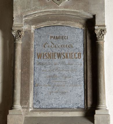 Zdjęcie nr 1: Epitafium architektoniczne, w formie aediculi, na cokole z wyciętym u dołu łukiem odcinkowym, ujęte parą kolumn o kapitelach korynckich, dźwigających niepełne belkowanie zakończone wyłamanym szerokim gzymsem. W partii zwieńczenia widnieje płaskorzeźbiona, ujęta liściastymi labrami tarcza z godłem herbu Prus I. Niegdyś epitafium wieńczył zapewne krzyż (obecnie zniszczony). Pośrodku profilowana płycina z inskrypcją „PAMIĘCI / Adama / WIŚNIEWSKIEGO / Dziedzica wsi Przebieczany / zm(arłego) d(nia) 6 Grudnia 1857 / w 64 roku życia. / Pozostała wdowa z dziećmi / poświęca”. W prawej dolnej części epitafium sygnatura „E(dward) Stehlik”.  