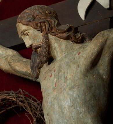 Zdjęcie nr 3: Rzeźba Chrystusa umarłego przybita do prostego krzyża trzema gwoździami. Ciało w lekkim zwisie o szeroko rozłożonych ramionach, układających się w delikatny łuk, głowa opadająca na prawy bark, nogi ugięte w kolanach, stopy skrzyżowane w układzie prawa na lewą. Chrystus ma pociągłą twarz, o migdałowatych, zamkniętych oczach, wąskim nosie i małych, rozchylonych ustach. Twarz okolona krótką, falowaną i rozdwajającą się w dwa pukle brodą oraz falowanymi włosami opadającymi na prawe ramię i kark. Ciało szczupłe, o delikatnym zarysowanym modelunku mięśni klatki piersiowej oraz ramion i nóg. Biodra przewiązane krótkim perizonium, zawiązanym na prawym boku. Ciało figury polichromowane naturalistycznie, włosy w kolorze brązowym, perizonium złocone. Na pionowej belce krzyża tabliczka z napisem „IN / RI”.

