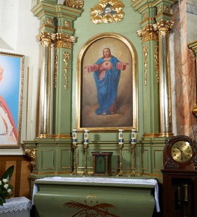 Zdjęcie nr 3: Obraz o fantazyjnej formie zbliżonej do stojącego prostokąta z wklęsłymi bokami, wypukłym dołem i górą. W centrum kompozycji św. Małgorzata ukazana w całej postaci, frontalnie, z głową skierowaną w lewo, w kontrapoście. Lewą ręką podtrzymuje na boku otwartą księgę i liść palmy, prawą duży krzyż. Twarz ma okrągłą, o migdałowatych oczach, skierowanych w górę, wąskim nosie i pełnych ustach, okoloną brązowymi włosami opadającymi na tył głowy. Ubrana jest w białą suknię, z gorsetem w pasie oraz niebieski płaszcz przerzucony diagonalnie przez lewe ramię i zawinięty na prawym ramieniu. Na ziemi, za postacią świętej leży smok. W górnej części obrazu nadlatujące putto, które trzyma wieniec laurowy nad głową Małgorzaty. Postać ukazana na tle pejzażu. 
