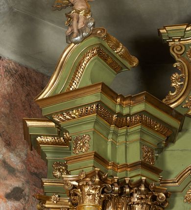 Zdjęcie nr 35: Nastawa ołtarzowa architektoniczna, jednoosiowa, jednokondygnacyjna ze zwieńczeniem, na cokole z czterema prostopadłościennymi postumentami wydzielonymi po bokach, z bramkami. Ołtarz drewniany, prostopadłościenny, z kamienną mensą z portatylem. Antependium drewniane obite miedzianą blachą, w formie leżącego prostokąta, ujętego profilowaną ramą, podzielone na dziesięć pól pasami z ornamentem geometrycznym, oraz aplikami w formie rautów na ich skrzyżowaniu. W środkowym polu monogram Marii oraz dwie apliki z orłem i pogonią u spodu. 
Retabulum flankowane ustawionymi schodkowo i zwróconymi na zewnątrz dwiema parami korynckich kolumn, umieszczonych na tle pilastrów oraz zewnętrzną parą pilastrów dekorowanych kwiatowymi zwisami. Podpory stoją na cokołach, podtrzymują wyłamane belkowanie, przerwane nad polem środkowym, oraz fragmenty przerwanego, falistego przyczółka z siedzącymi na obłokach puttami. W polu środkowym wnęka w formie stojącego prostokąta zamkniętego łukiem półkolistym nadwieszonym z uskokiem w profilowanej ramie, z obrazem św. Marcina. Pole środkowe zamknięte gzymsem przyjmującym kształt łuku odcinkowego nadwieszonego z rokokowym kartuszem z napisem &quot;AVE / MARIA / GRATIA PLENA / LUC. 1.28&quot; oraz z podwieszonymi dwiema różanymi gałązkami. Obraz flankowany dwoma zwisami na wstędze utworzonymi z kwiatów. Kondygnacja ujęta ażurowymi uszami utworzonymi z rocaille&#039;u, kratki i kwiatów. Zwieńczenie w formie zbliżonej po stojącego prostokąta o wklęsłych bokach ujętych spływami wolutowymi z rocaille&#039;m, zamkniętego gzymsem przyjmującym kształt łuku półkolistego nadwieszonego z uskokiem, wyłamanego przy krawędziach, zwieńczonego anthemionem. W polu obraz św. Józefa z Dzieciątkiem w formie zbliżonej do trapezu o wklęsłych bokach i wypukłych podstawach, w ramie. Ujęty z trzech stron wicią roślinną. Bramki na wysokości cokołu nastawy, w formie półkolistych, profilowanych arkad podtrzymywanych na pilastrach o kanelowanych trzonach. Arkady zwieńczone cokołami, na których ustawione są figury św. Wojciecha i św. Stanisława. Struktura polichromowana w kolorze seledynowym, ze złoconymi kolumnami, profilami i ornamentyką.


