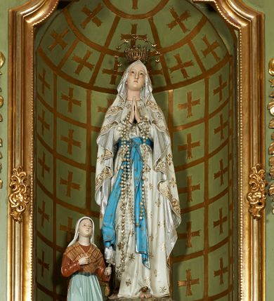 Zdjęcie nr 53: Nastawa ołtarzowa architektoniczna, jednoosiowa, jednokondygnacyjna ze zwieńczeniem, na cokole z czterema prostopadłościennymi postumentami wydzielonymi po bokach, z bramkami. Ołtarz drewniany, prostopadłościenny, z kamienną mensą z portatylem. Antependium drewniane obite miedzianą blachą, w formie leżącego prostokąta, ujętego profilowaną ramą, podzielone na dziesięć pól pasami z ornamentem geometrycznym, oraz aplikami w formie rautów na ich skrzyżowaniu. W środkowym polu monogram Marii oraz dwie apliki z orłem i pogonią u spodu. 
Retabulum flankowane ustawionymi schodkowo i zwróconymi na zewnątrz dwiema parami korynckich kolumn, umieszczonych na tle pilastrów oraz zewnętrzną parą pilastrów dekorowanych kwiatowymi zwisami. Podpory stoją na cokołach, podtrzymują wyłamane belkowanie, przerwane nad polem środkowym, oraz fragmenty przerwanego, falistego przyczółka z siedzącymi na obłokach puttami. W polu środkowym wnęka w formie stojącego prostokąta zamkniętego łukiem półkolistym nadwieszonym z uskokiem w profilowanej ramie, z obrazem św. Marcina. Pole środkowe zamknięte gzymsem przyjmującym kształt łuku odcinkowego nadwieszonego z rokokowym kartuszem z napisem "AVE / MARIA / GRATIA PLENA / LUC. 1.28" oraz z podwieszonymi dwiema różanymi gałązkami. Obraz flankowany dwoma zwisami na wstędze utworzonymi z kwiatów. Kondygnacja ujęta ażurowymi uszami utworzonymi z rocaille'u, kratki i kwiatów. Zwieńczenie w formie zbliżonej po stojącego prostokąta o wklęsłych bokach ujętych spływami wolutowymi z rocaille'm, zamkniętego gzymsem przyjmującym kształt łuku półkolistego nadwieszonego z uskokiem, wyłamanego przy krawędziach, zwieńczonego anthemionem. W polu obraz św. Józefa z Dzieciątkiem w formie zbliżonej do trapezu o wklęsłych bokach i wypukłych podstawach, w ramie. Ujęty z trzech stron wicią roślinną. Bramki na wysokości cokołu nastawy, w formie półkolistych, profilowanych arkad podtrzymywanych na pilastrach o kanelowanych trzonach. Arkady zwieńczone cokołami, na których ustawione są figury św. Wojciecha i św. Stanisława. Struktura polichromowana w kolorze seledynowym, ze złoconymi kolumnami, profilami i ornamentyką.


