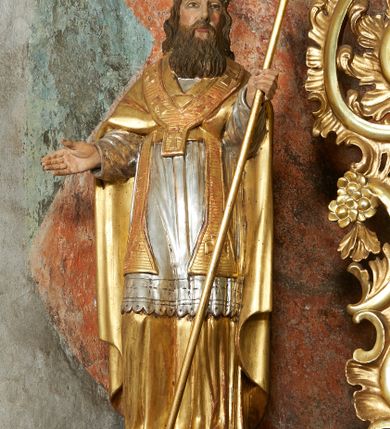 Zdjęcie nr 6: Nastawa ołtarzowa architektoniczna, jednoosiowa, jednokondygnacyjna ze zwieńczeniem, na cokole z czterema prostopadłościennymi postumentami wydzielonymi po bokach, z bramkami. Ołtarz drewniany, prostopadłościenny, z kamienną mensą z portatylem. Antependium drewniane obite miedzianą blachą, w formie leżącego prostokąta, ujętego profilowaną ramą, podzielone na dziesięć pól pasami z ornamentem geometrycznym, oraz aplikami w formie rautów na ich skrzyżowaniu. W środkowym polu monogram Marii oraz dwie apliki z orłem i pogonią u spodu. 
Retabulum flankowane ustawionymi schodkowo i zwróconymi na zewnątrz dwiema parami korynckich kolumn, umieszczonych na tle pilastrów oraz zewnętrzną parą pilastrów dekorowanych kwiatowymi zwisami. Podpory stoją na cokołach, podtrzymują wyłamane belkowanie, przerwane nad polem środkowym, oraz fragmenty przerwanego, falistego przyczółka z siedzącymi na obłokach puttami. W polu środkowym wnęka w formie stojącego prostokąta zamkniętego łukiem półkolistym nadwieszonym z uskokiem w profilowanej ramie, z obrazem św. Marcina. Pole środkowe zamknięte gzymsem przyjmującym kształt łuku odcinkowego nadwieszonego z rokokowym kartuszem z napisem &quot;AVE / MARIA / GRATIA PLENA / LUC. 1.28&quot; oraz z podwieszonymi dwiema różanymi gałązkami. Obraz flankowany dwoma zwisami na wstędze utworzonymi z kwiatów. Kondygnacja ujęta ażurowymi uszami utworzonymi z rocaille&#039;u, kratki i kwiatów. Zwieńczenie w formie zbliżonej po stojącego prostokąta o wklęsłych bokach ujętych spływami wolutowymi z rocaille&#039;m, zamkniętego gzymsem przyjmującym kształt łuku półkolistego nadwieszonego z uskokiem, wyłamanego przy krawędziach, zwieńczonego anthemionem. W polu obraz św. Józefa z Dzieciątkiem w formie zbliżonej do trapezu o wklęsłych bokach i wypukłych podstawach, w ramie. Ujęty z trzech stron wicią roślinną. Bramki na wysokości cokołu nastawy, w formie półkolistych, profilowanych arkad podtrzymywanych na pilastrach o kanelowanych trzonach. Arkady zwieńczone cokołami, na których ustawione są figury św. Wojciecha i św. Stanisława. Struktura polichromowana w kolorze seledynowym, ze złoconymi kolumnami, profilami i ornamentyką.


