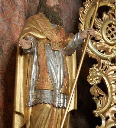 Zdjęcie nr 4: Nastawa ołtarzowa architektoniczna, jednoosiowa, jednokondygnacyjna ze zwieńczeniem, na cokole z czterema prostopadłościennymi postumentami wydzielonymi po bokach, z bramkami. Ołtarz drewniany, prostopadłościenny, z kamienną mensą z portatylem. Antependium drewniane obite miedzianą blachą, w formie leżącego prostokąta, ujętego profilowaną ramą, podzielone na dziesięć pól pasami z ornamentem geometrycznym, oraz aplikami w formie rautów na ich skrzyżowaniu. W środkowym polu monogram Marii oraz dwie apliki z orłem i pogonią u spodu. 
Retabulum flankowane ustawionymi schodkowo i zwróconymi na zewnątrz dwiema parami korynckich kolumn, umieszczonych na tle pilastrów oraz zewnętrzną parą pilastrów dekorowanych kwiatowymi zwisami. Podpory stoją na cokołach, podtrzymują wyłamane belkowanie, przerwane nad polem środkowym, oraz fragmenty przerwanego, falistego przyczółka z siedzącymi na obłokach puttami. W polu środkowym wnęka w formie stojącego prostokąta zamkniętego łukiem półkolistym nadwieszonym z uskokiem w profilowanej ramie, z obrazem św. Marcina. Pole środkowe zamknięte gzymsem przyjmującym kształt łuku odcinkowego nadwieszonego z rokokowym kartuszem z napisem "AVE / MARIA / GRATIA PLENA / LUC. 1.28" oraz z podwieszonymi dwiema różanymi gałązkami. Obraz flankowany dwoma zwisami na wstędze utworzonymi z kwiatów. Kondygnacja ujęta ażurowymi uszami utworzonymi z rocaille'u, kratki i kwiatów. Zwieńczenie w formie zbliżonej po stojącego prostokąta o wklęsłych bokach ujętych spływami wolutowymi z rocaille'm, zamkniętego gzymsem przyjmującym kształt łuku półkolistego nadwieszonego z uskokiem, wyłamanego przy krawędziach, zwieńczonego anthemionem. W polu obraz św. Józefa z Dzieciątkiem w formie zbliżonej do trapezu o wklęsłych bokach i wypukłych podstawach, w ramie. Ujęty z trzech stron wicią roślinną. Bramki na wysokości cokołu nastawy, w formie półkolistych, profilowanych arkad podtrzymywanych na pilastrach o kanelowanych trzonach. Arkady zwieńczone cokołami, na których ustawione są figury św. Wojciecha i św. Stanisława. Struktura polichromowana w kolorze seledynowym, ze złoconymi kolumnami, profilami i ornamentyką.


