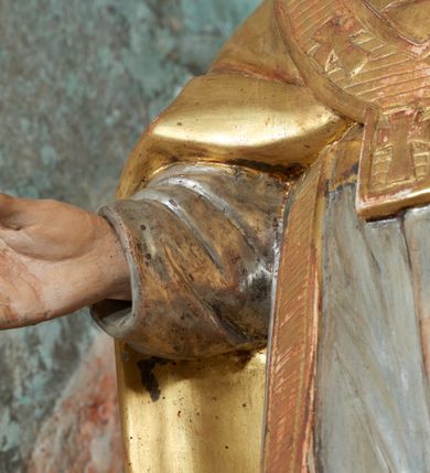 Zdjęcie nr 12: Nastawa ołtarzowa architektoniczna, jednoosiowa, jednokondygnacyjna ze zwieńczeniem, na cokole z czterema prostopadłościennymi postumentami wydzielonymi po bokach, z bramkami. Ołtarz drewniany, prostopadłościenny, z kamienną mensą z portatylem. Antependium drewniane obite miedzianą blachą, w formie leżącego prostokąta, ujętego profilowaną ramą, podzielone na dziesięć pól pasami z ornamentem geometrycznym, oraz aplikami w formie rautów na ich skrzyżowaniu. W środkowym polu monogram Marii oraz dwie apliki z orłem i pogonią u spodu. 
Retabulum flankowane ustawionymi schodkowo i zwróconymi na zewnątrz dwiema parami korynckich kolumn, umieszczonych na tle pilastrów oraz zewnętrzną parą pilastrów dekorowanych kwiatowymi zwisami. Podpory stoją na cokołach, podtrzymują wyłamane belkowanie, przerwane nad polem środkowym, oraz fragmenty przerwanego, falistego przyczółka z siedzącymi na obłokach puttami. W polu środkowym wnęka w formie stojącego prostokąta zamkniętego łukiem półkolistym nadwieszonym z uskokiem w profilowanej ramie, z obrazem św. Marcina. Pole środkowe zamknięte gzymsem przyjmującym kształt łuku odcinkowego nadwieszonego z rokokowym kartuszem z napisem &quot;AVE / MARIA / GRATIA PLENA / LUC. 1.28&quot; oraz z podwieszonymi dwiema różanymi gałązkami. Obraz flankowany dwoma zwisami na wstędze utworzonymi z kwiatów. Kondygnacja ujęta ażurowymi uszami utworzonymi z rocaille&#039;u, kratki i kwiatów. Zwieńczenie w formie zbliżonej po stojącego prostokąta o wklęsłych bokach ujętych spływami wolutowymi z rocaille&#039;m, zamkniętego gzymsem przyjmującym kształt łuku półkolistego nadwieszonego z uskokiem, wyłamanego przy krawędziach, zwieńczonego anthemionem. W polu obraz św. Józefa z Dzieciątkiem w formie zbliżonej do trapezu o wklęsłych bokach i wypukłych podstawach, w ramie. Ujęty z trzech stron wicią roślinną. Bramki na wysokości cokołu nastawy, w formie półkolistych, profilowanych arkad podtrzymywanych na pilastrach o kanelowanych trzonach. Arkady zwieńczone cokołami, na których ustawione są figury św. Wojciecha i św. Stanisława. Struktura polichromowana w kolorze seledynowym, ze złoconymi kolumnami, profilami i ornamentyką.


