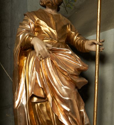 Zdjęcie nr 4: Nastawa ołtarzowa architektoniczna, jednoosiowa, jednokondygnacyjna ze zwieńczeniem, ustawiona na cokole z dwoma prostopadłościennymi postumentami wydzielonymi po bokach, z bramkami w partii cokołu. Ołtarz drewniany, prostopadłościenny, zwężający się ku dołowi, dekorowany z przodu rzeźbionym wieńcem z monogramem Marii, mensa drewniana. Na mensie ustawione tabernakulum w formie drewnianej skrzynki o ściętych przednich narożach, flankowanej parą kolumienek. Drzwiczki w formie stojącego prostokąta dekorowane płyciną. Nastawa ołtarzowa ujęta parą kolumn o stylizowanych kapitelach kompozytowych dźwigających pełne belkowanie, przerwane nad polem środkowym, oraz fragmenty przerwanego, półkolistego przyczółka, na którym klęczą na obłokach dwa putta. Fryz dekorowany ornamentem roślinnym zbliżonym do akantu. W polu głównym wnęka w formie stojącego prostokąta w profilowanej ramie, z obrazem Koronacji Marii. Nad nim medalion utworzony z akantu z monogramem Marii, zwieńczony koroną zamkniętą. Zwieńczenie w formie trapezu, którego brzegi dekorowane są stylizowanym rocaille&#039;m tworzącym uszaki. W polu obraz św. Józefa w formie trapezu o ściętych dolnych narożach, zamkniętego łukiem półkolistym nadwieszonym, w profilowanej ramie, z łukiem częściowo przesłoniętym obłokami z dwoma uskrzydlonymi główkami anielskimi. Nastawa zakończona medalionem z obłoków z Okiem Opatrzności w glorii promienistej. Nastawę flankują bramki w partii cokołu z przejściami w formie stojącego prostokąta zamkniętego łukiem odcinkowym nadwieszonym, zakończone profilowanym gzymsem oraz cokołami dekorowanymi roślinnymi konsolami, na których stoją figury św. Anny i św. Joachima. Struktura polichromowana w kolorze seledynowym, ze złoconymi kolumnami, profilami i  ornamentyką. 
