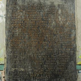 Zdjęcie nr 1: Płyta w formie stojącego prostokąta. W polu złocona inskrypcja: „D[EO] O[PTIMO] M[AXIMO] / ZIMNY MARMVR POKRIWAM PROCHV MIZERNEGO / SCZVPLA RESZTE KTORA TV DNIA CZEKA SADNEGO. / TE SZYMON Z KALINOWA KALINOWSKI W GROBIE / ZŁOZYŁ VPODOBAWSZY ODPOCYNEK SOBIE / PO WOIENNYCH FATIGACH KTORE Z KONIECPOLSKIEM / ZOSTAIAC KASTELANEM NA ONCZASZ KRAKOWSKIM / WODZEM SWOIM PONOSIEŁ MALBORSKIE SWIADKAMI / MVRY IAK MEZNIE STAWIAŁ W BITWIE ZE SZWEDA[M]I / SWIADKIEM CZVDNOW KOZACKA GDZIE SPRZISIEGŁA SIE A / ZDVMNEM MOSKALEM ZGVBE OYCZYZNIE WROZYŁA / IAK KAWALERSKO STAWAŁ GDZIE PRZESZ WOYSKA MESTWO / WSPANIAŁE ODEBRAŁA KORONA ZWYCIESTWO / POTYM GDY NOWE BVNTY KOZACZTWO WZNIECIEŁO / ZA DNIEPREM A WOYSKO SIE KORONNE SKUPIEŁO / POD GŁVCHOW BYŁ W POTRZEBIE DZIELNOSC V WAZONO / I W PODNIESTRZV ZAWODZIC STRAZE  MV ZLECONO. / W PRETCZE  ZAS GDY CZESC WOISKA POD TARNOPOL STAWA / WODZ IEMV STRAZNIKOSTWO WOYSKOWE ODDAWA / Z POCHWAŁA TO ODPRAWIEŁ BIEŁ SIE POTYM MEZNIE / NA BATOHV Z TATARY TESZ ORDE POTESZNIE / POD KALVSZA KVMARNEM GROMIEŁ YZ TVRKAMI / VGANIAŁ SIE WIELEKROC WSZYKV Y HARCAMI / SKONCZYŁ WOYNE KRWIA TVRSKA POLA NAPOIWSZY / CHOCIMSKIE A ZIEMIANSKI ZYWOT VLVBIWSZY / W TYM KOSCIELE GOEZINKI NIEPOKALANEGO / FVNDOWAŁ MATKO BOSKA POCZECIA TWOIEGO. / WIEC ZA TRVDY WOIENNE CZEKAIAC KORONY / DO TWEI SIE PANI SWIATA VCIEKA OBRONY / VPROS MV ZYWOT WIECZNY WSZAK MV NIENOWINA / BYLO LAC KREW ZA CALOSC WIARY TWEGO SYNA / VMARŁ DNIA [...] ROKV [...] / WIEKV SWEGO LAT [...]”. W górnym lewym rogu płyty ryty herb Ślepowron z inskrypcją: „[Z DOMV KALINOWSKI]CH ZRODZICA”. W górnym prawym rogu ryty herb Gozdawa z inskrypcją: „[Z DOMV SOKO]/LOWSKICH ZM[ATKI]”. W dolnym lewym rogu herb Pilawa z inskrypcją: „[Z] DOMV POROWSK/[I]CH PRABABY”. W dolnym prawym rogu herb Massalski z inskrypcją: „Z DOMV MASS/ALSKICH ZBABY”. 


