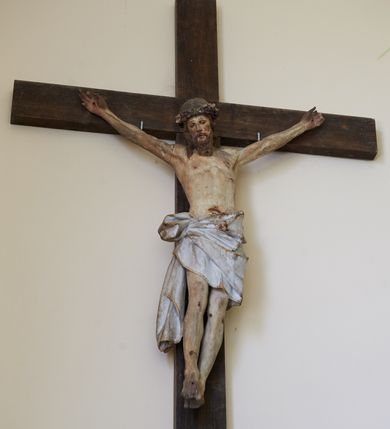 Zdjęcie nr 4: Figura Chrystusa żywego przybitego trzema gwoździami do prostego krzyża. Ciało w lekkim zwisie, o szeroko rozłożonych ramionach, lekko łukowato wygiętych, głowa przechylona na prawy bark, nogi wyprostowane, stopy skrzyżowane w układzie prawa na lewą. Twarz ma podłużną, o półprzymkniętych oczach, małym nosie i pełnych ustach, okoloną falowaną brodą i włosami sięgającymi ramion. Na głowie korona cierniowa. Ciało szczupłe, muskularne, o delikatnie podkreślonym modelunku klatki piersiowej i ramion. Biodra przesłonięte obszernym, silnie drapowanym, białym perizonium ze złoconą lamówką, sięgającym połowy uda, zawiązanym na prawym boku, z długim zwisem tkaniny wzdłuż prawej nogi. Polichromia ciała naturalistyczna z zaznaczonymi śladami męki. 