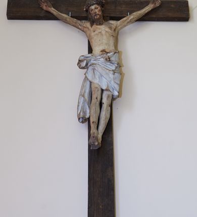 Zdjęcie nr 2: Figura Chrystusa żywego przybitego trzema gwoździami do prostego krzyża. Ciało w lekkim zwisie, o szeroko rozłożonych ramionach, lekko łukowato wygiętych, głowa przechylona na prawy bark, nogi wyprostowane, stopy skrzyżowane w układzie prawa na lewą. Twarz ma podłużną, o półprzymkniętych oczach, małym nosie i pełnych ustach, okoloną falowaną brodą i włosami sięgającymi ramion. Na głowie korona cierniowa. Ciało szczupłe, muskularne, o delikatnie podkreślonym modelunku klatki piersiowej i ramion. Biodra przesłonięte obszernym, silnie drapowanym, białym perizonium ze złoconą lamówką, sięgającym połowy uda, zawiązanym na prawym boku, z długim zwisem tkaniny wzdłuż prawej nogi. Polichromia ciała naturalistyczna z zaznaczonymi śladami męki. 